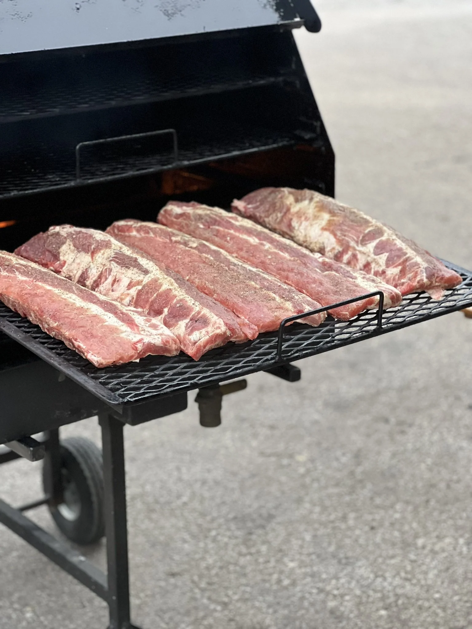 Elm Creek Beef Raw ribs placed on a grill for cooking outdoors.