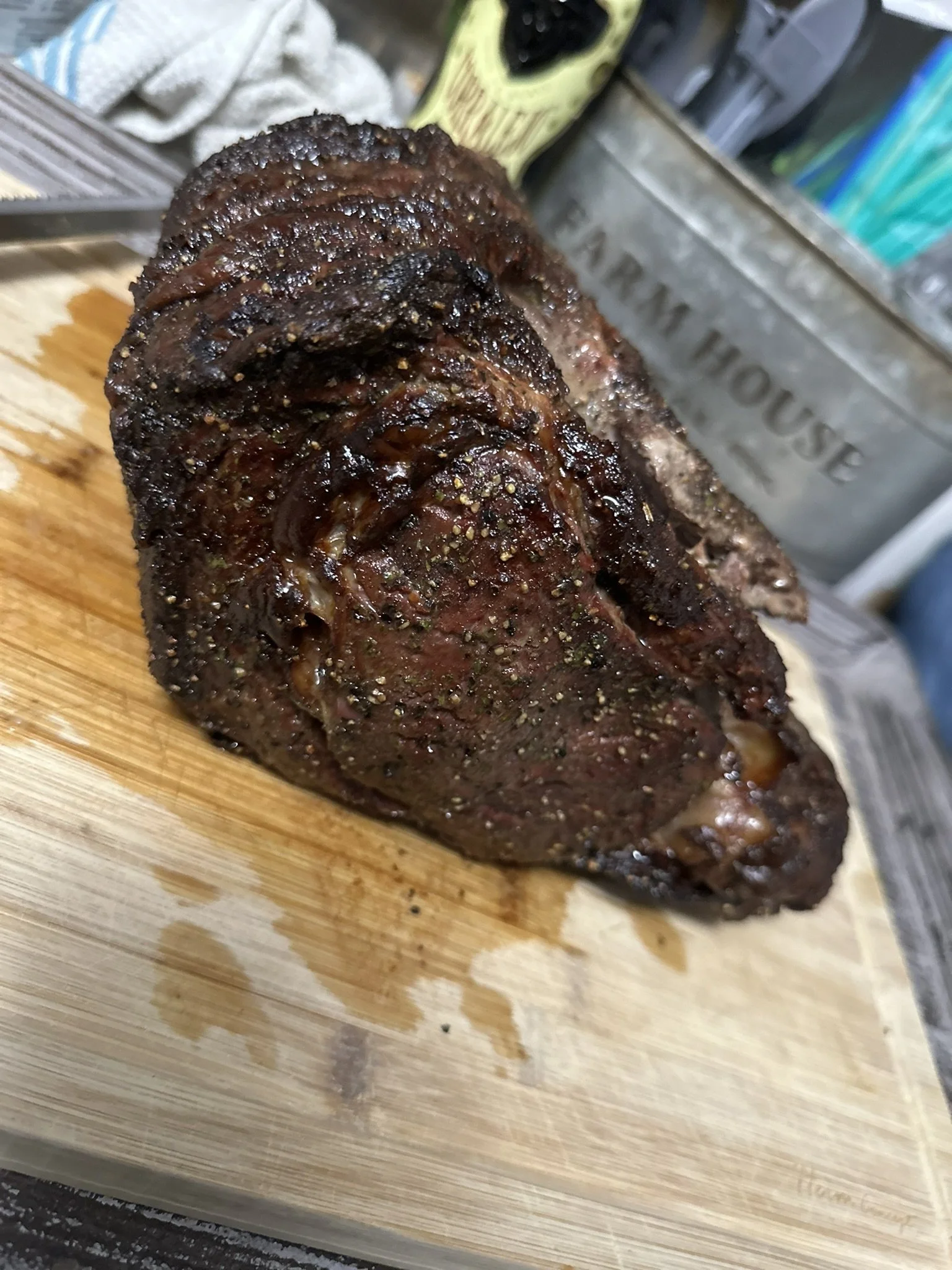 Elm Creek Beef Cooked beef roast seasoned with black pepper on a wooden cutting board.