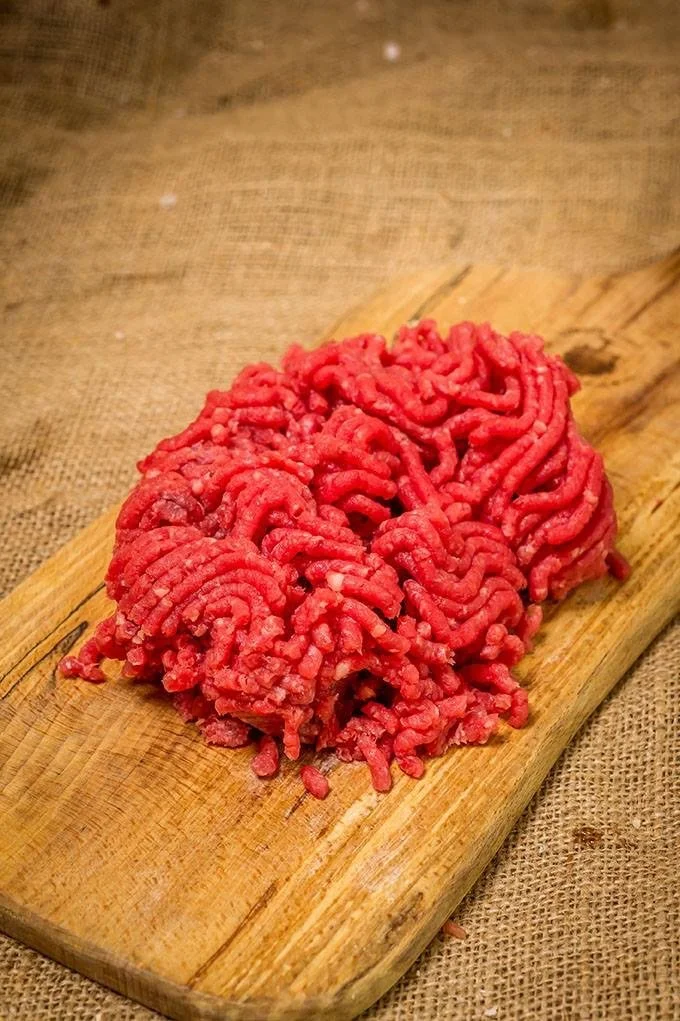 Elm Creek Beef Raw ground beef on a wooden cutting board.