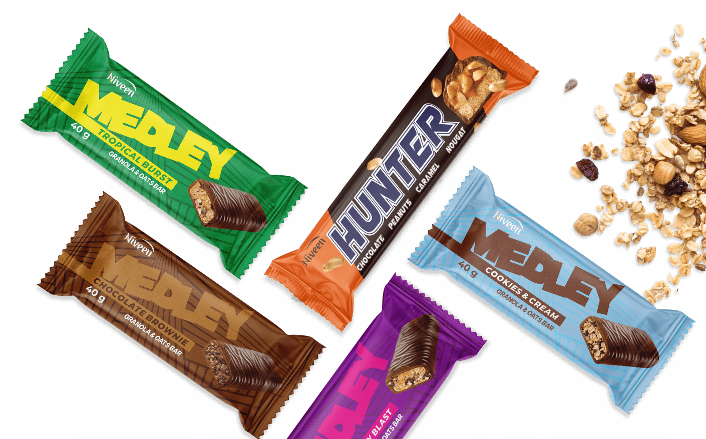 Five different flavored Niveen Medley snack bars on a white plate with scattered granola, oats, nuts, and dried fruit on the side.