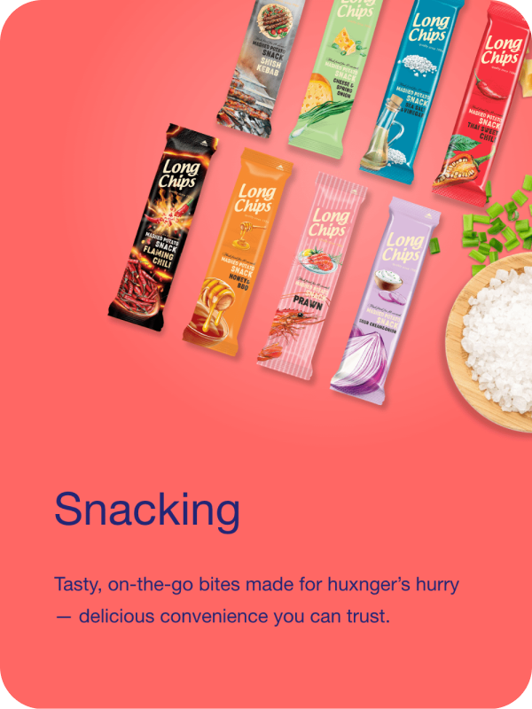 Various flavors of long potato chip snack packages laid out on a pink background next to a bowl of rice and some chopped green onions. The flavors include flaming chili, honey BBQ, prawn, sour cream onion, and chili.