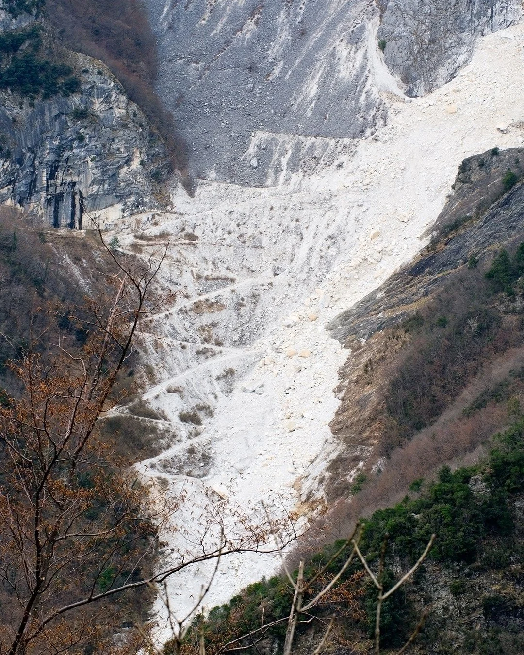Winter in Carrara. The holidays linger, the roads are quiet, and the mountains settle into stillness. Quarry paths trace the landscape in pale stone, softened by winter light and silence.

A moment of calm before the rhythm of the year resumes&mdash;