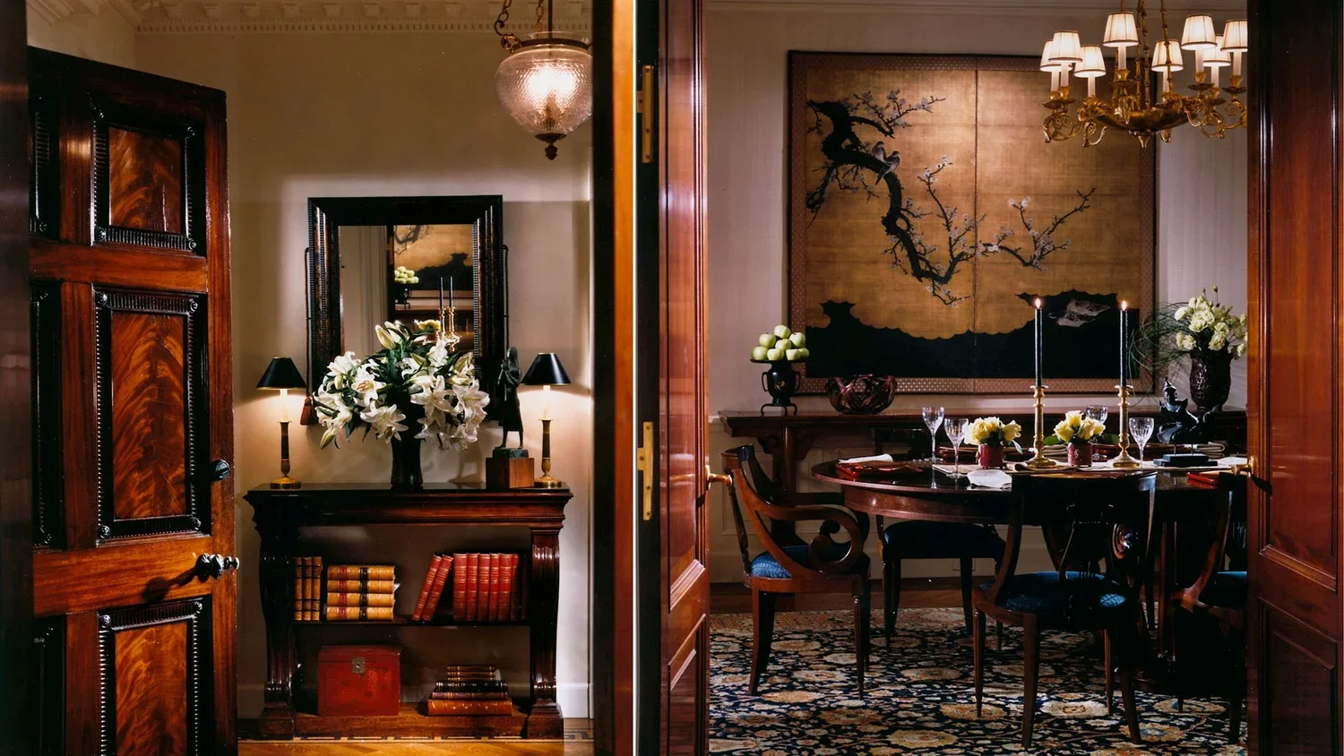 Elegant dining room with a large wooden dining table, candle holders, wine glasses, floral arrangements, and a chandelier. The room features antique-style furniture and Japanese art on the wall.