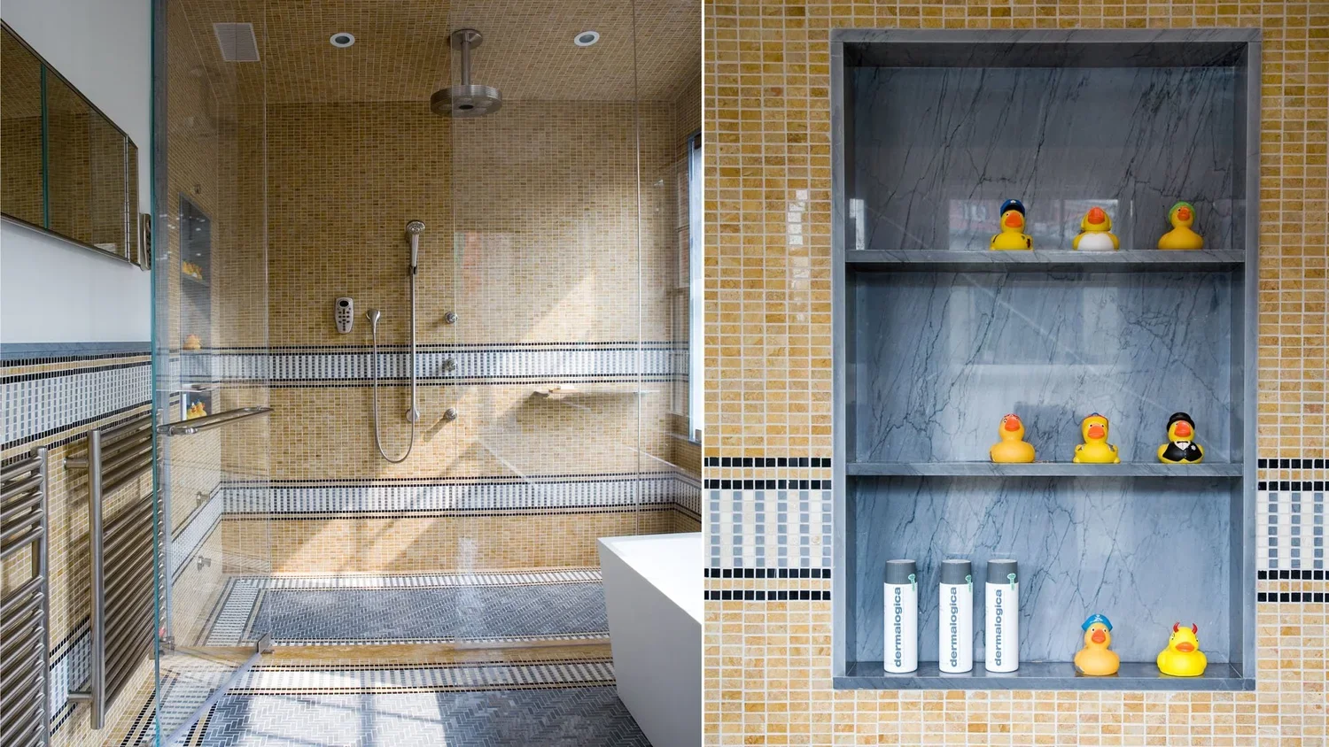 A bathroom with a glass shower enclosure on the left and a wall with shelves on the right. The shower has beige and black mosaic tiles and a rainfall showerhead. The shelves on the right hold rubber ducks and skincare product bottles.