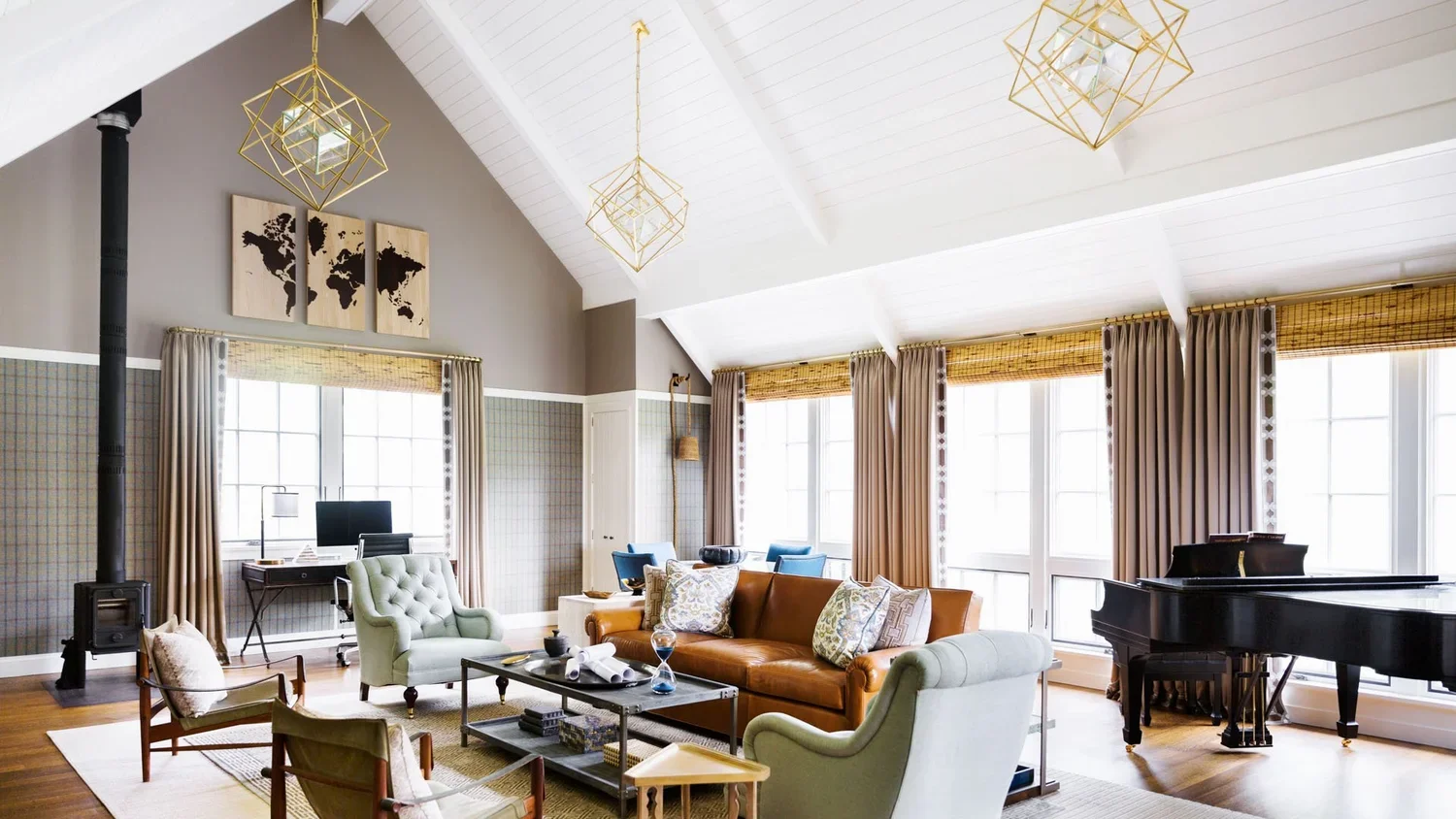 Bright living room with large windows, beige and green furniture, a black grand piano, and modern geometric light fixtures, with world map wall art above.