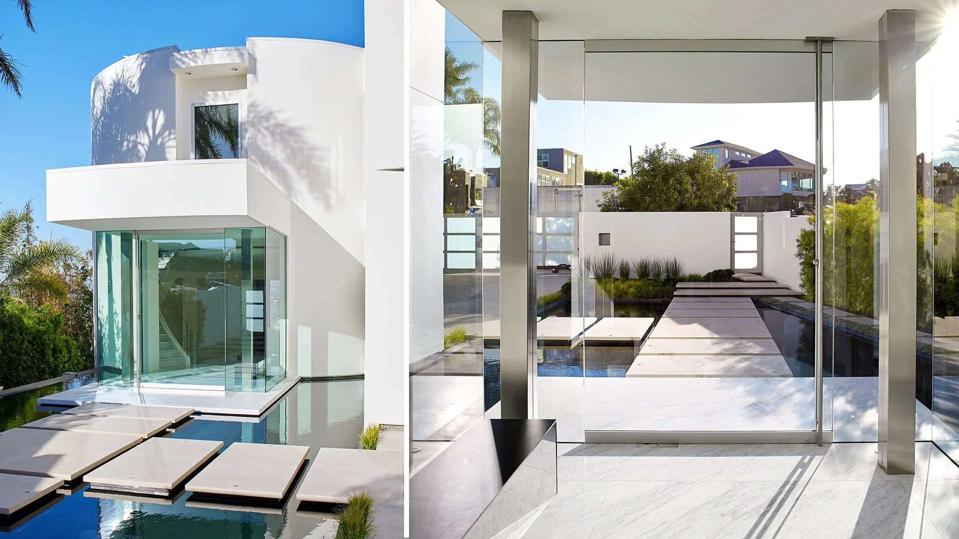 Modern white house has large glass porch and stepping stones leading to a gate with landscaping.
