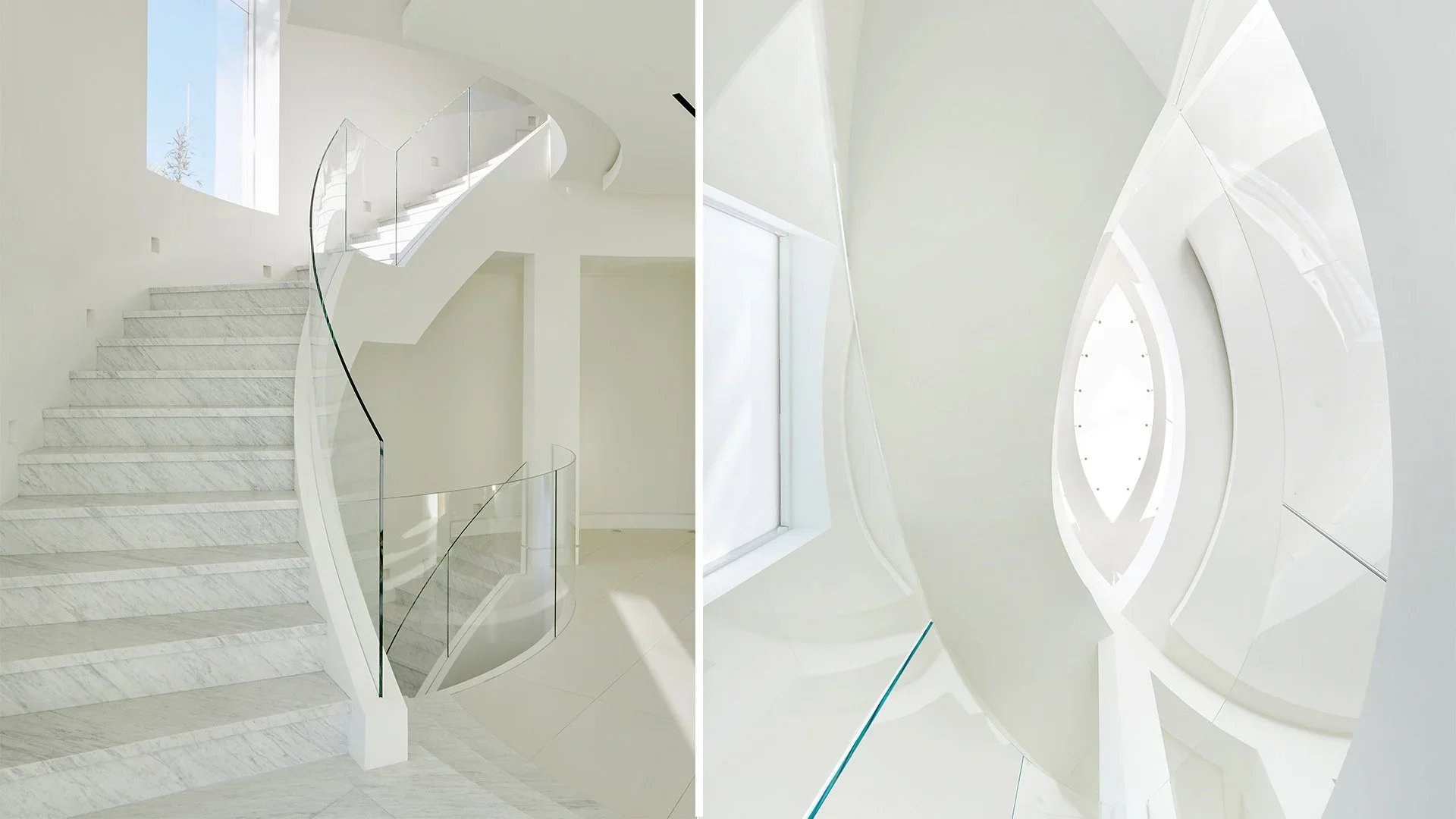Modern staircase with white marble steps, glass railing, and curved architectural design inside a bright white interior space.