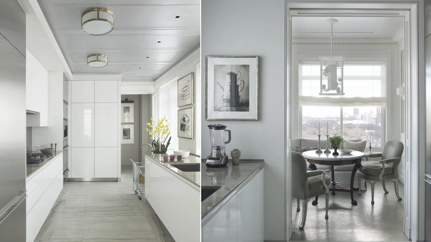 Open-concept kitchen and dining room with white cabinetry, a marble floor, and a round dining table with four chairs near large windows showing city views.