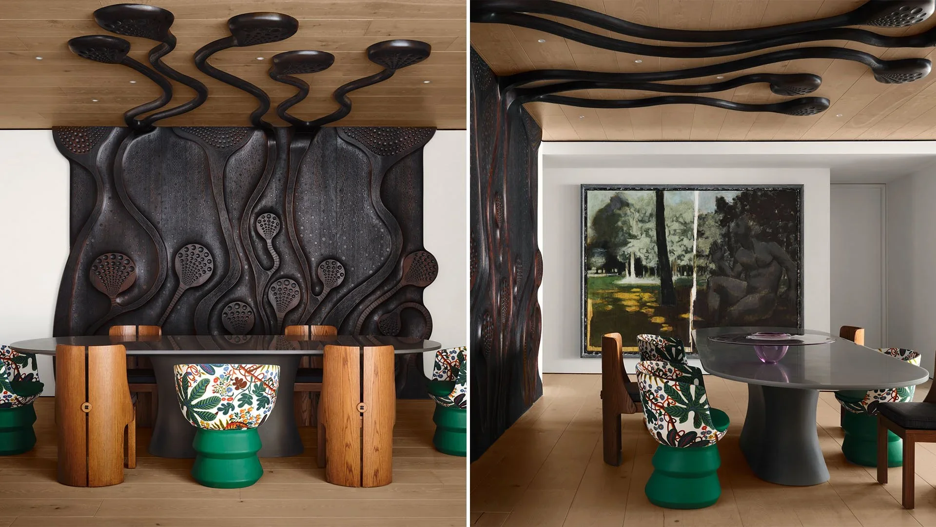 Interior of a modern room with a black sculptural wall piece, colorful patterned chairs, a round black table with a purple sculpture, and a large landscape painting on the white wall.