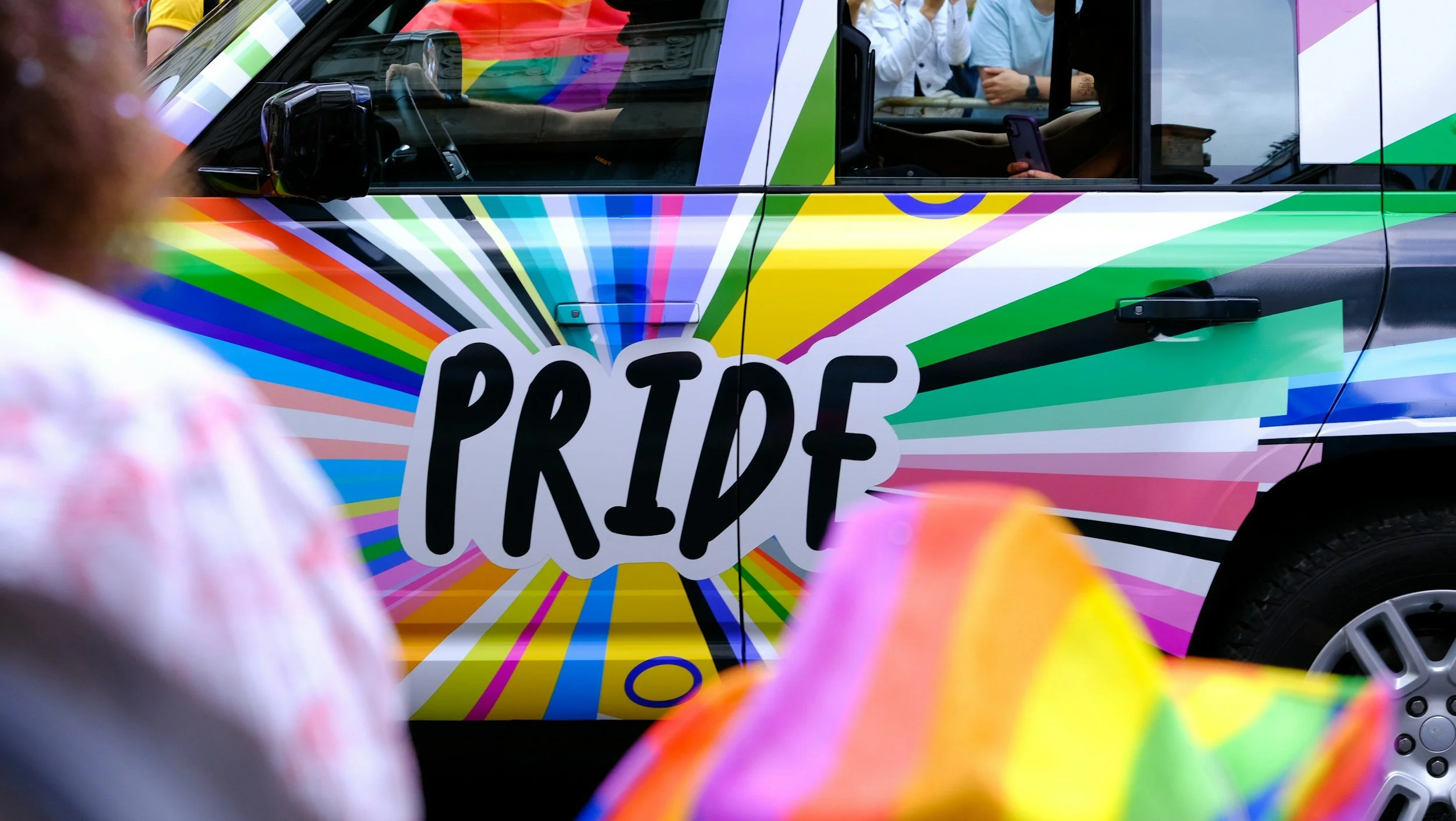 Van painted in the colours of various LGBTQ+ flags with the word 'Pride' along the side.