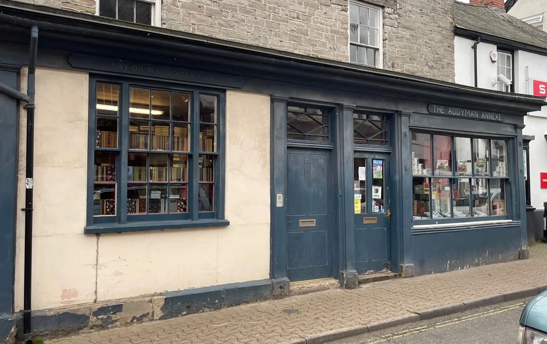 Addyman's Annexe shop front facade. Single storey shop with green window frames and doors.
