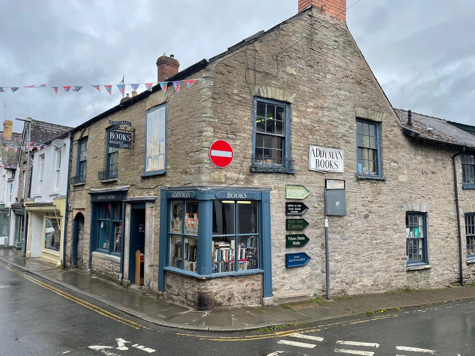 Addyman Books shop front. Old stone with green window frames.