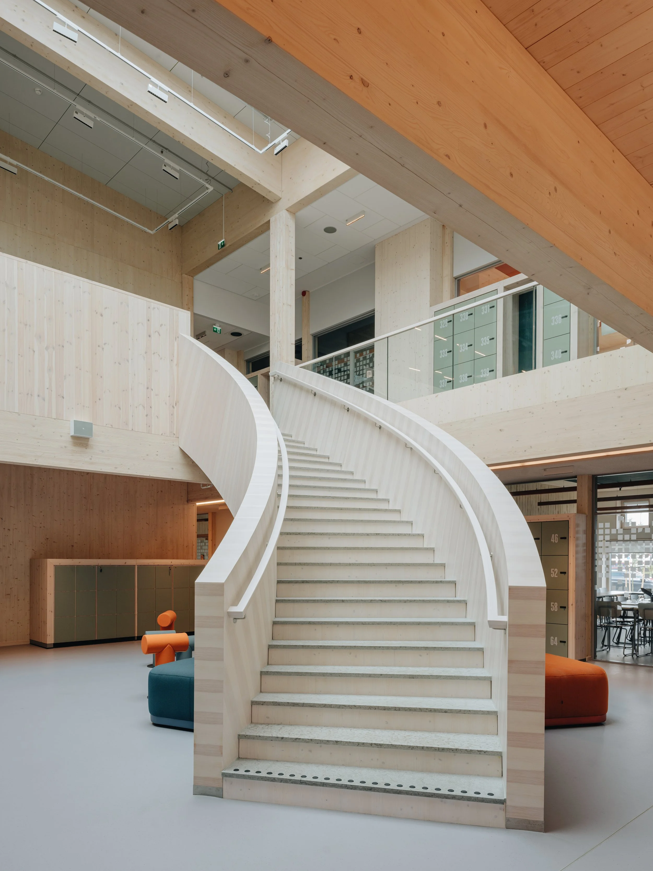 Modern interior with a curved staircase, wooden accents, and open spaces.