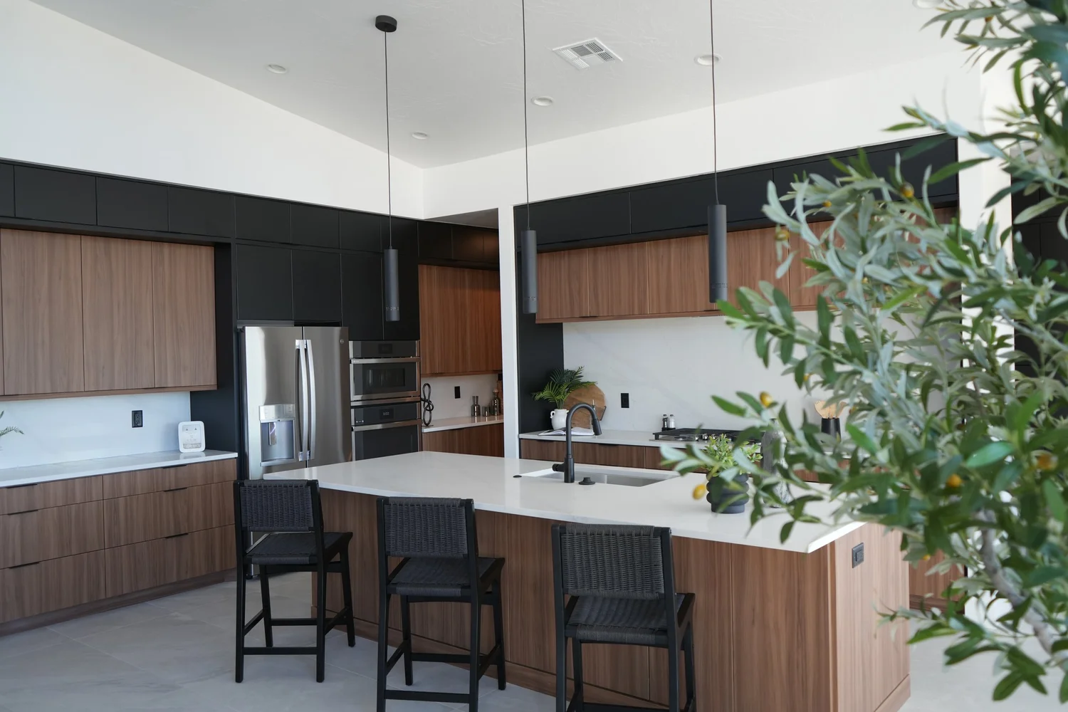 Modern custom home kitchen with wood cabinetry and white island built by Urban Desert Homes in St. George, Utah