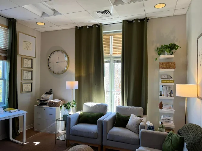 A cozy therapy office with comfortable armchairs and a window with sunlight streaming in at Stafford and Associates Counseling in Mooresville, NC