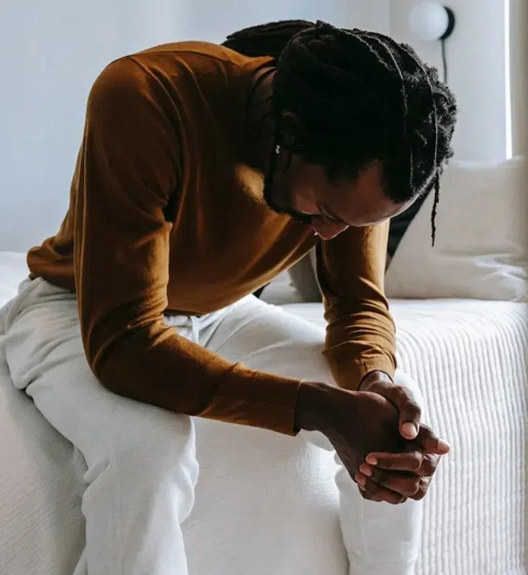 A man looking downward suffering from anxiety.