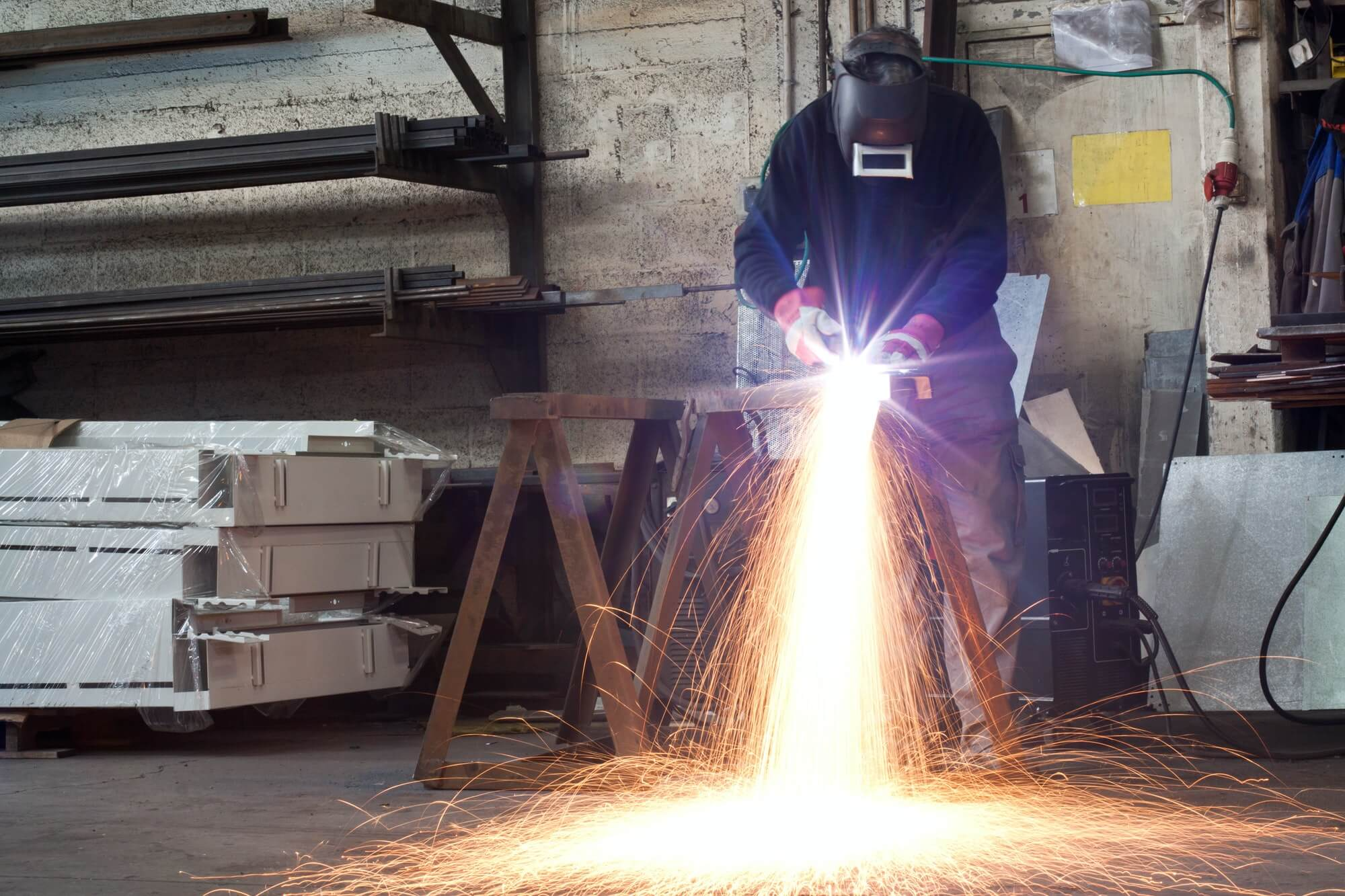 A worker welding metal sparks flying in a workshop.