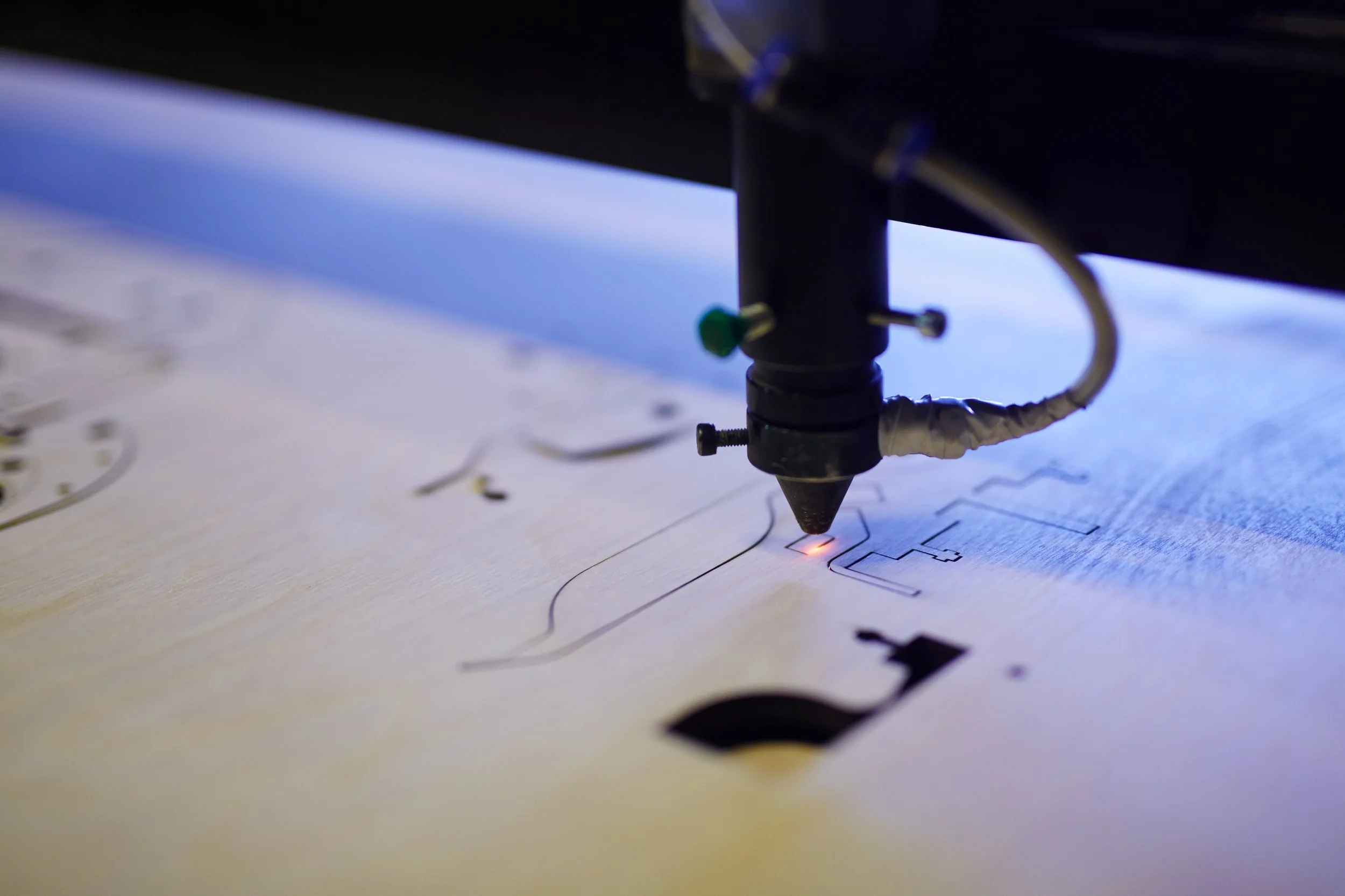 Close-up of a laser cutter engraving a design onto wood.