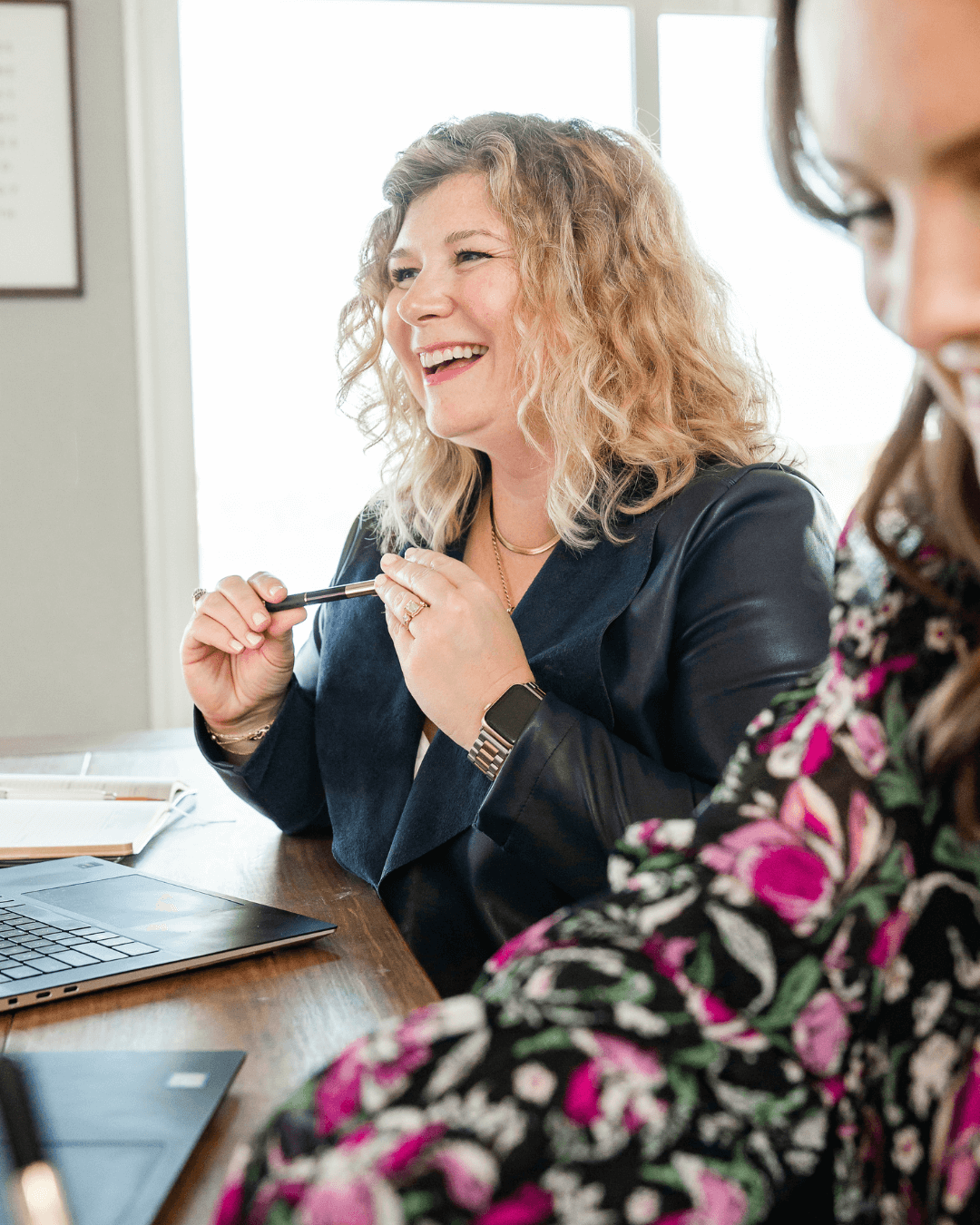 Lauren Cockerell laughs with clients during a collaborative meeting, sharing insights on PR strategy and audience engagement.