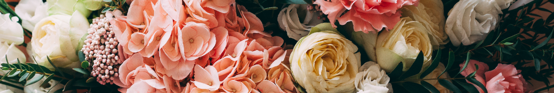 A bouquet of pink, white, and yellow flowers with green foliage.