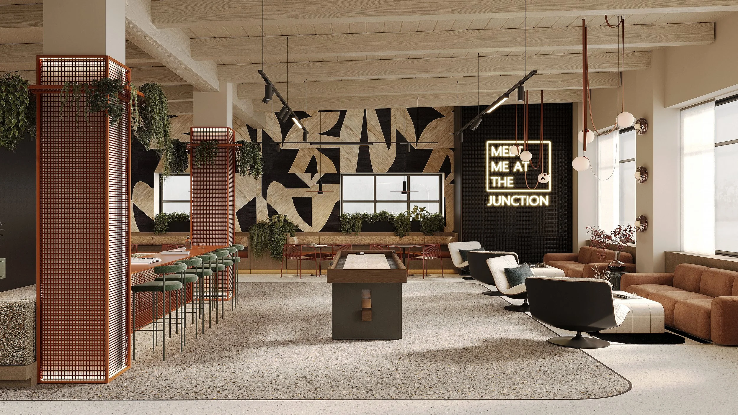 Modern, stylish lounge with seating area, green plants, and decorative lighting, featuring a neon sign that reads 'MEET ME AT THE JUNCTION'.