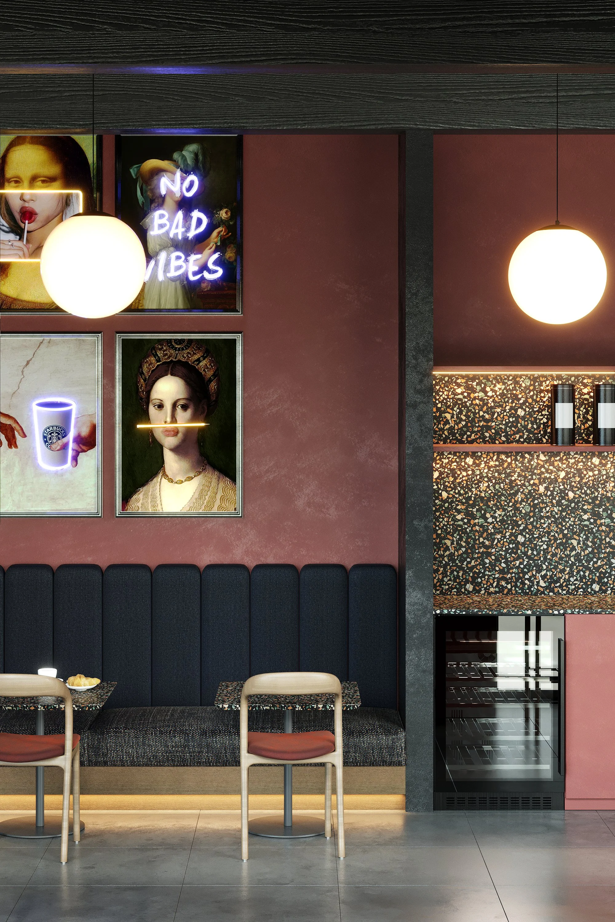 Interior of a modern cafe with pink walls, black bench seating, two light-colored chairs, framed art prints, and neon signs, including one that says 'No Bad Vibes' and another showing a woman with a neon lip and a drink.