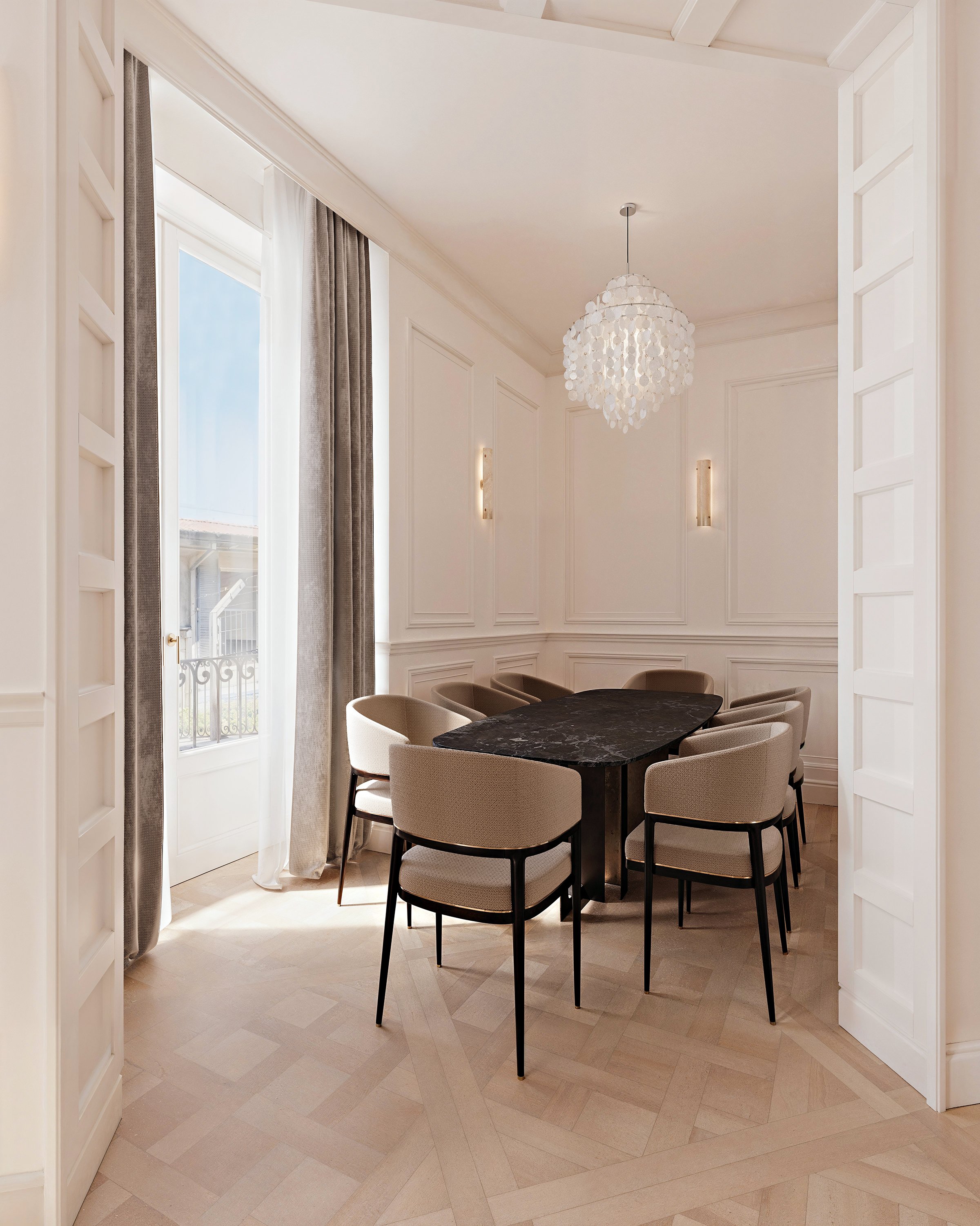 Sala da pranzo elegante con pareti bianche, grandi finestre con tende beige, tavolo nero e sedie beige