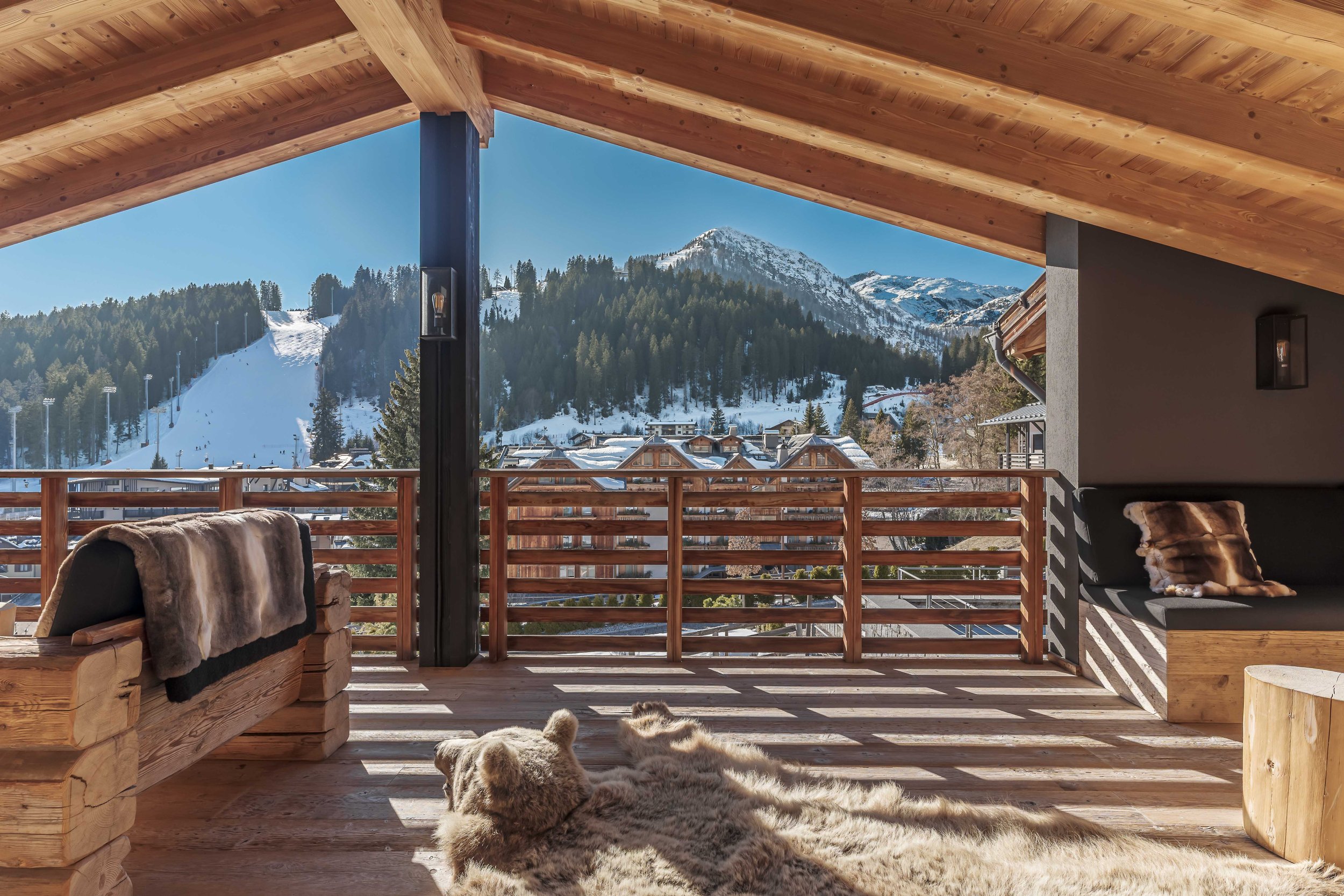 Hotelfotograf Südtirol, professionelle Fotografie für Hotels und Resorts — Offene Terrasse Holzbalken Pelzdecke Bergblick