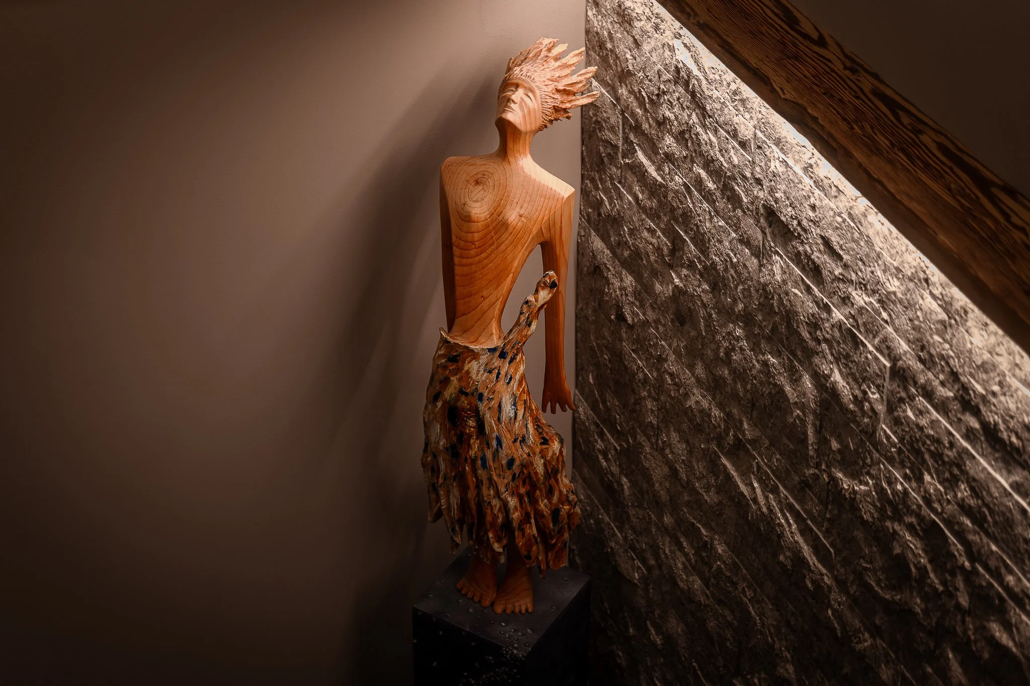 Hotelfotograf Südtirol, professionelle Fotografie für Hotels und Resorts — Holzskulptur Figur Steinwand Warmes Licht