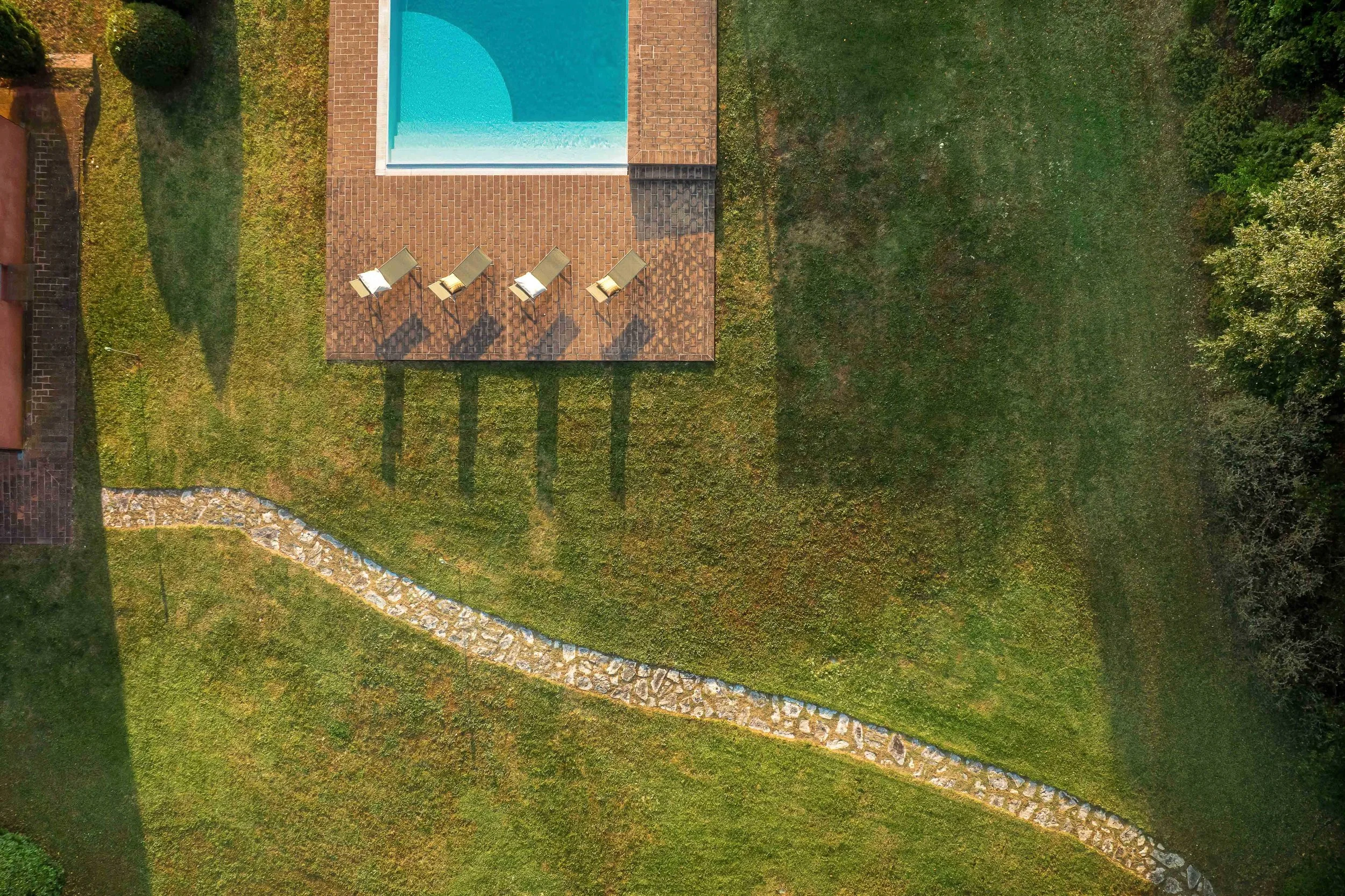 Fotografo per agriturismi nel Chianti. Fotografia professionale per strutture ricettive in Chianti e Toscana. Foto con drone di una piscina nelle campagne al tramonto.