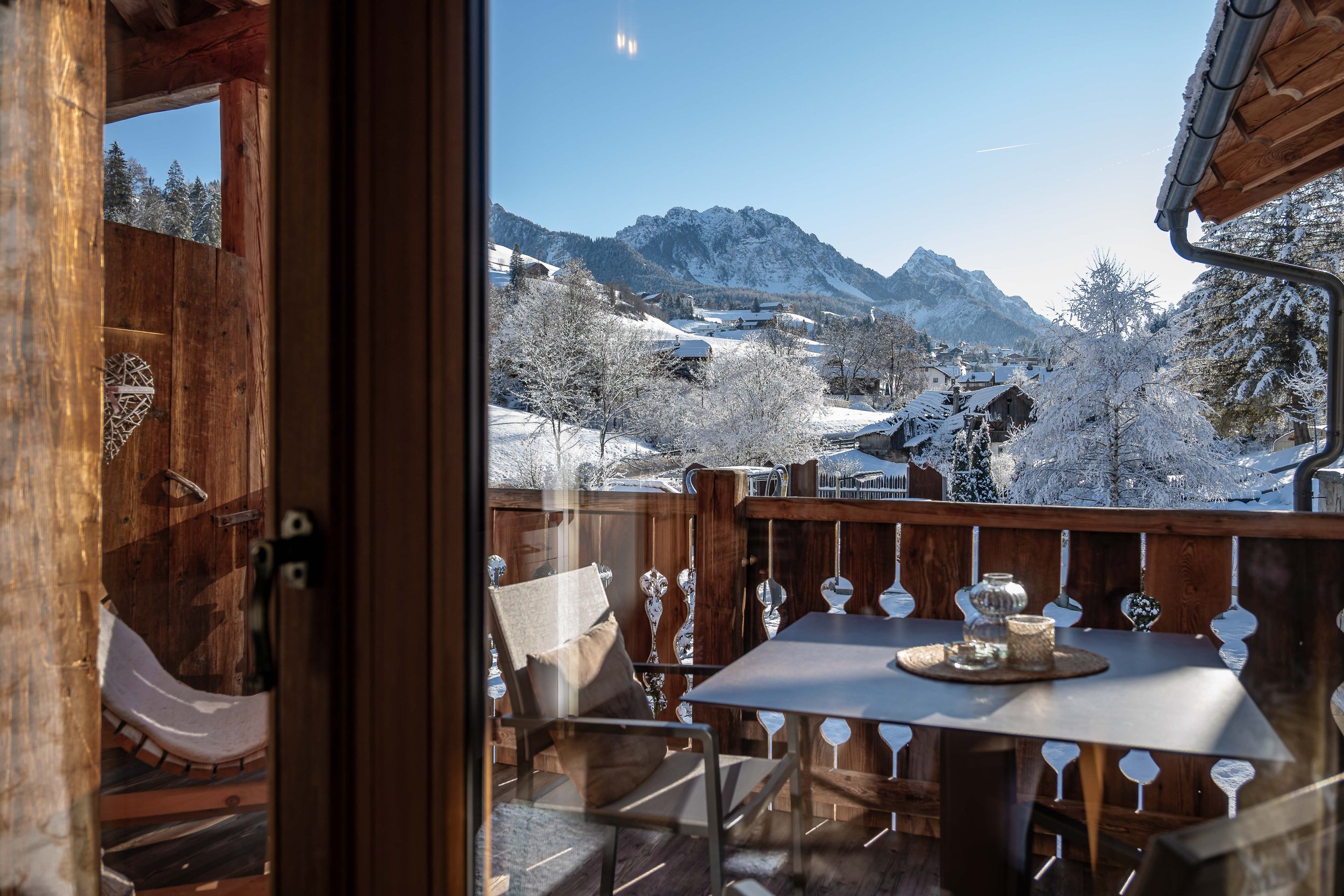 Hotelfotograf Südtirol, professionelle Fotografie für Hotels und Resorts — Holzterrasse Bergpanorama Schneelandschaft Tisch