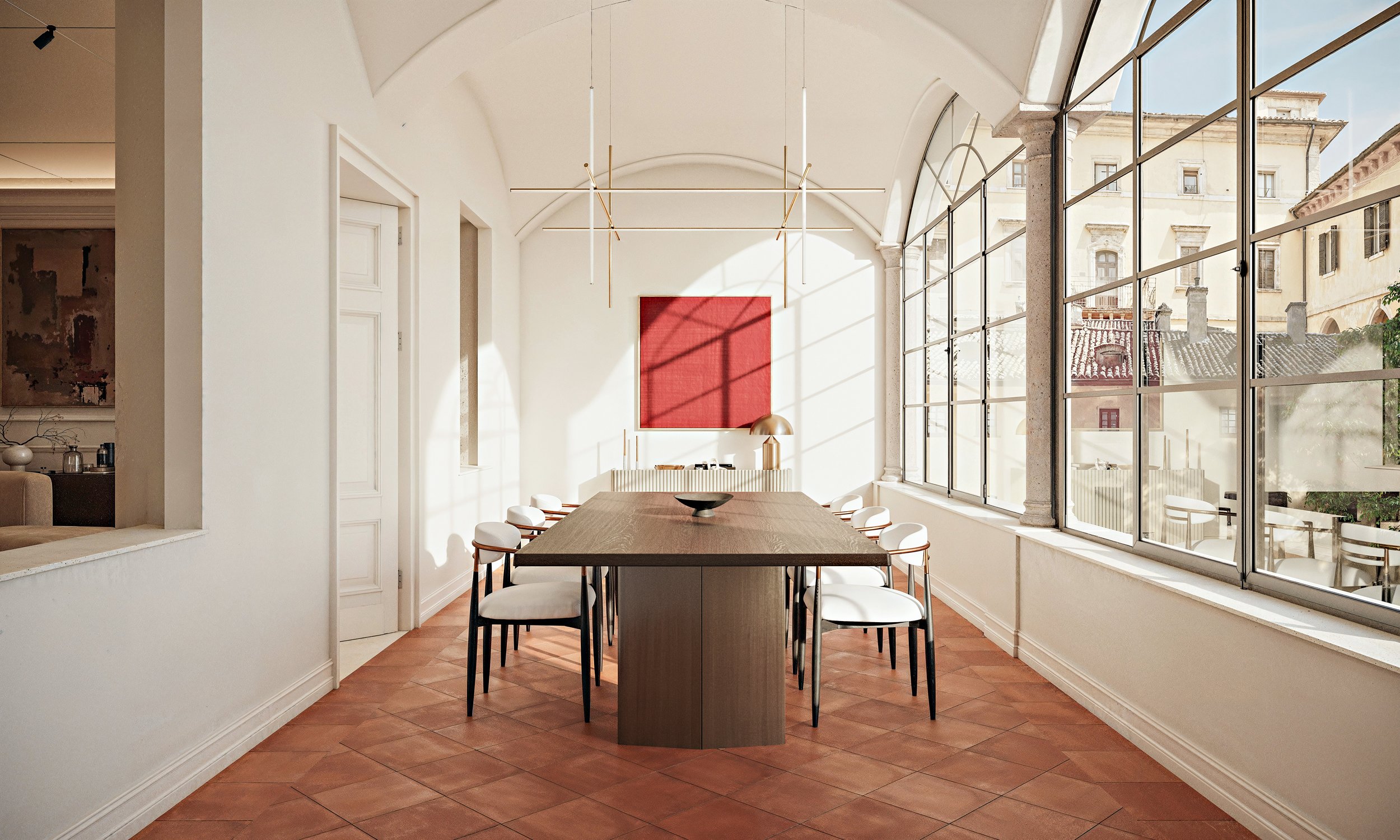 Sala da pranzo luminosa con grandi vetrate, tavolo in legno e sedie bianche. Murale rosso e lampade moderne sopra il tavolo.