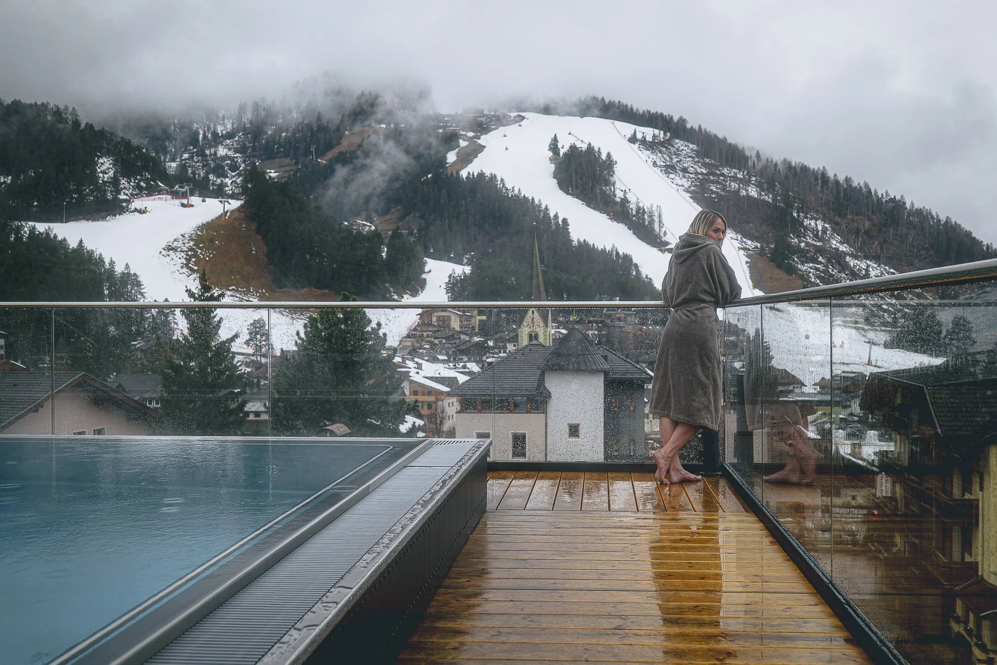 Hotelfotograf Südtirol, professionelle Fotografie für Hotels und Resorts — Infinity Pool Aussenbereich Nebel Bergblick Frau