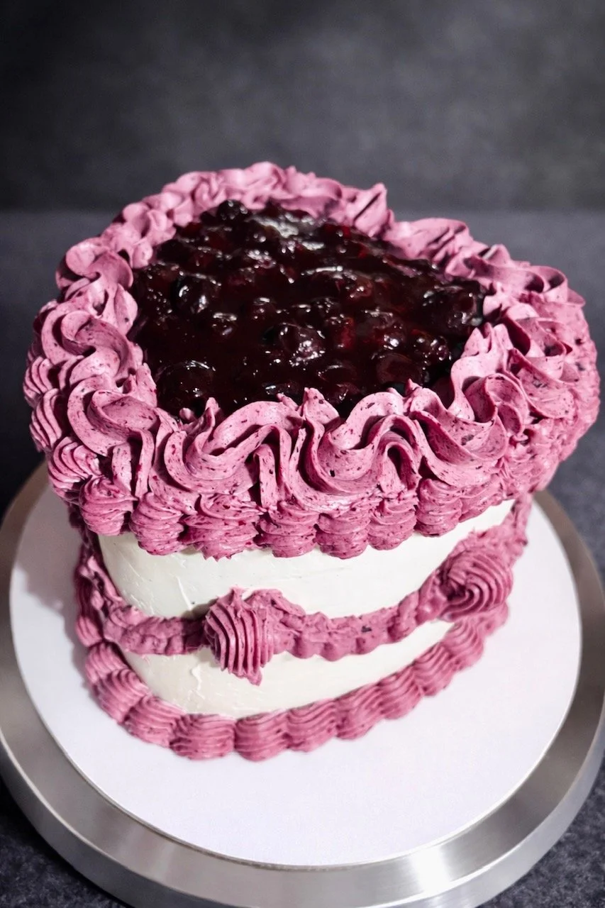 Funfetti 6in Heart Cake w/ House-made Blueberry Compote, Vanilla Buttercream w/ Vintage Blueberry Buttercream Piping.