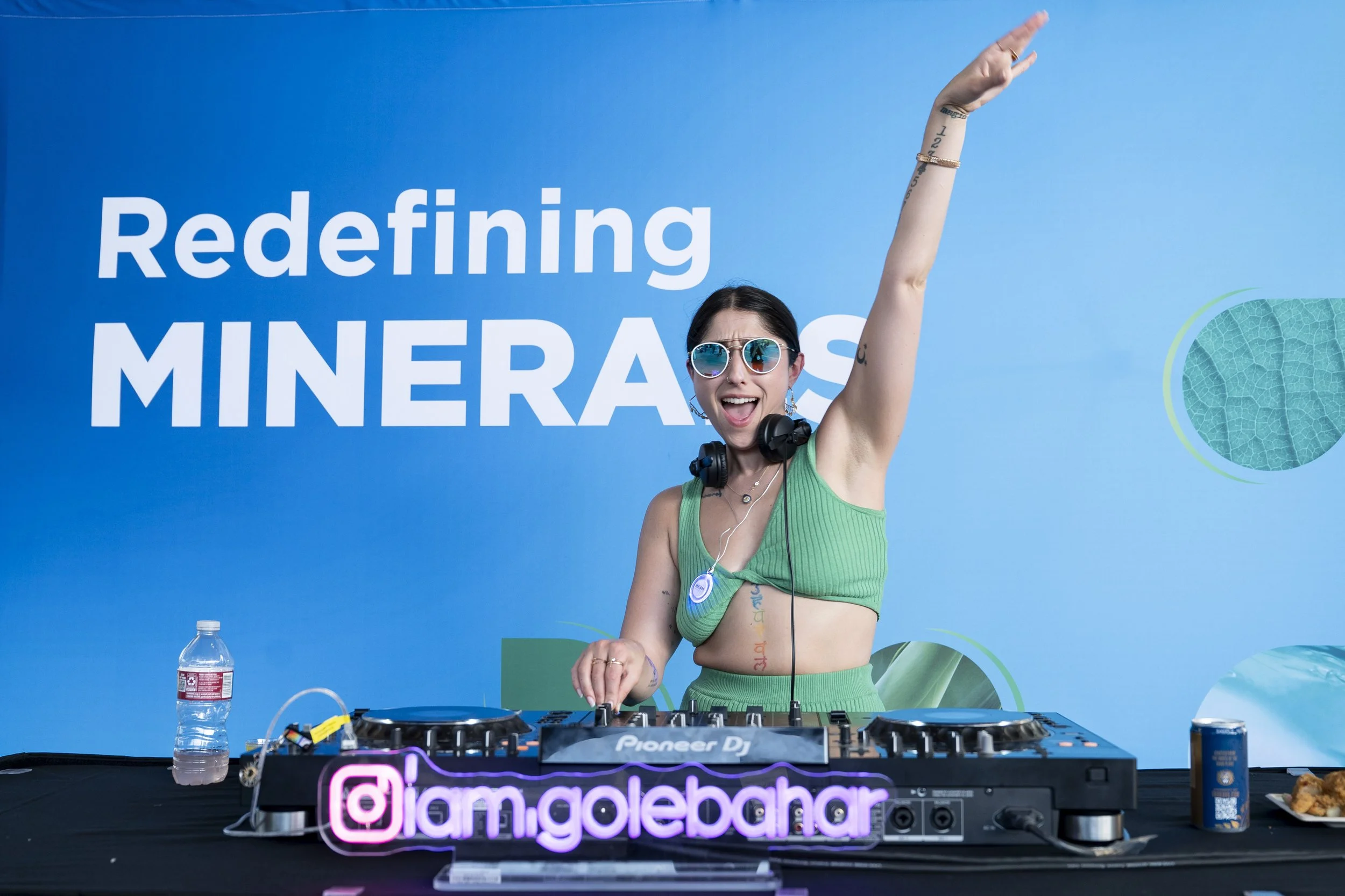 Non-binary DJ performing at happy hour at wellness conference 