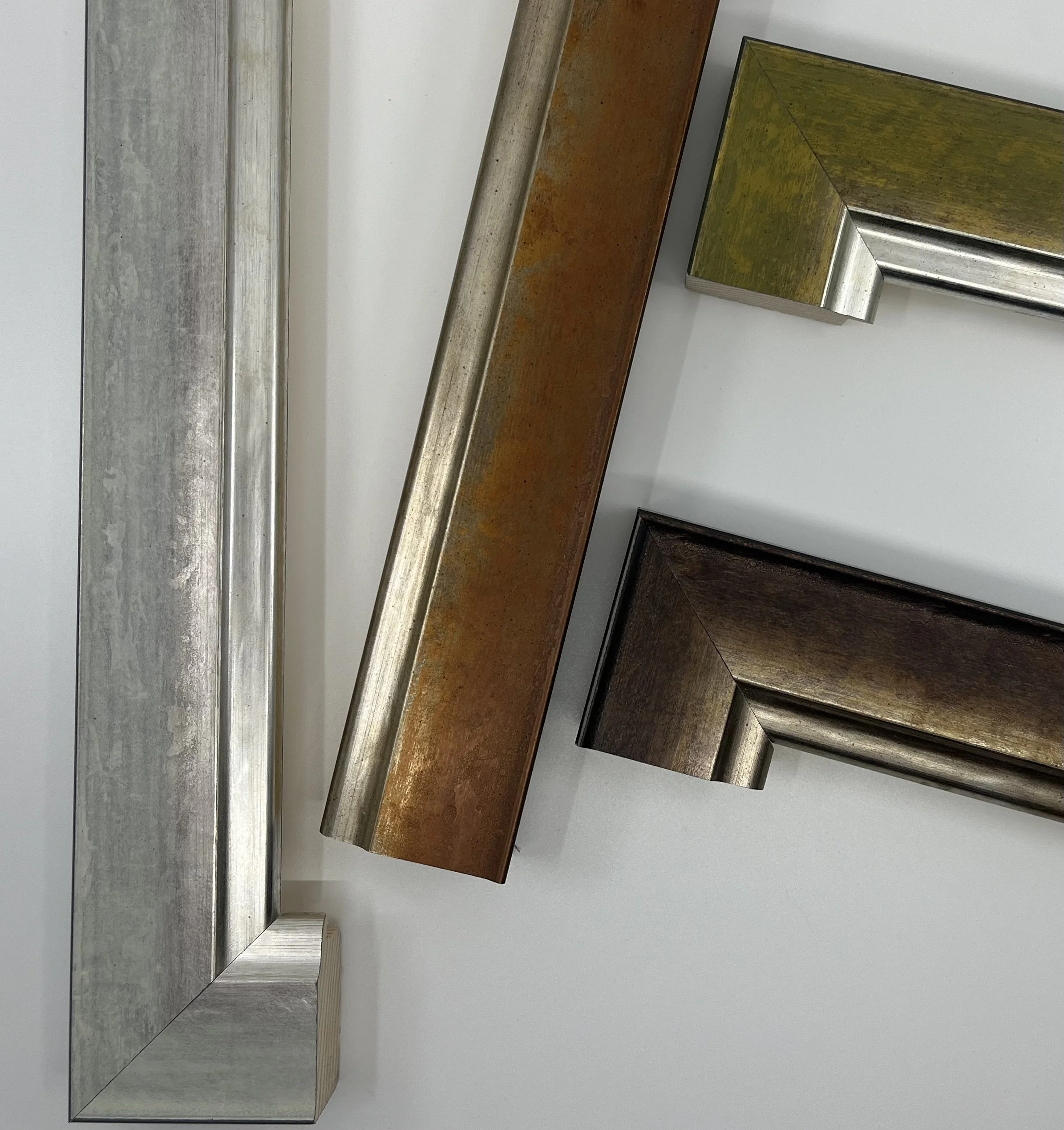 Dettaglio aste per cornici con finiture bronzo e argento per forniture all’ingrosso — LgM Cornici, Ferrara.