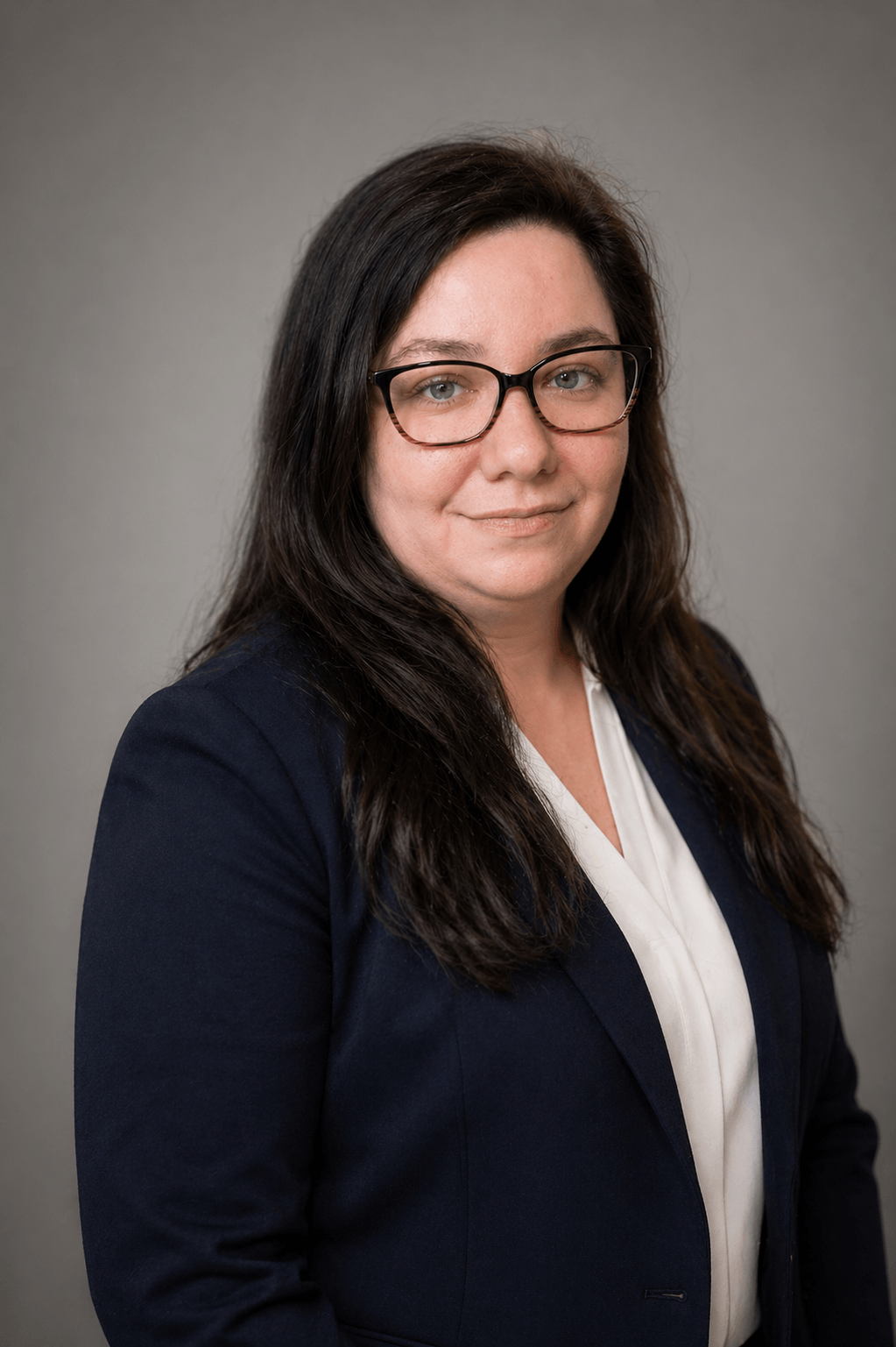 Friendly professional bookkeeper headshot wearing green blouse against grey background