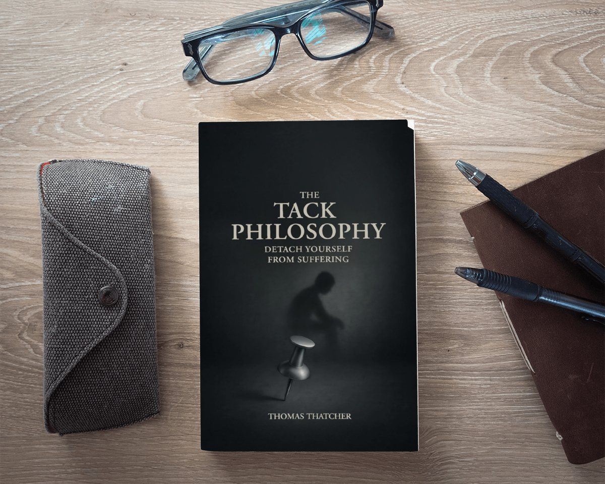 A book titled "The Tack Philosophy" by Thomas Thatcher, a pair of glasses, a gray case, a brown notebook with two pens, and a pair of glasses on a wooden surface.