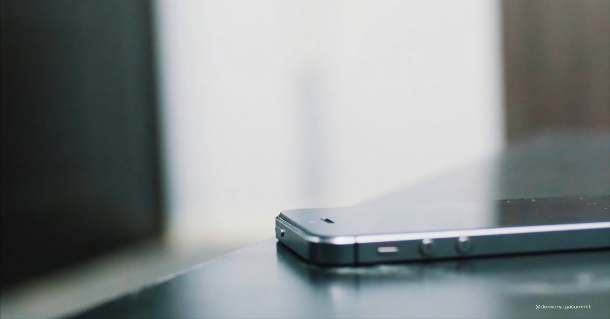 Phone placed face down on a table, representing brahmacharya in daily life and the practice of choosing where your attention goes.