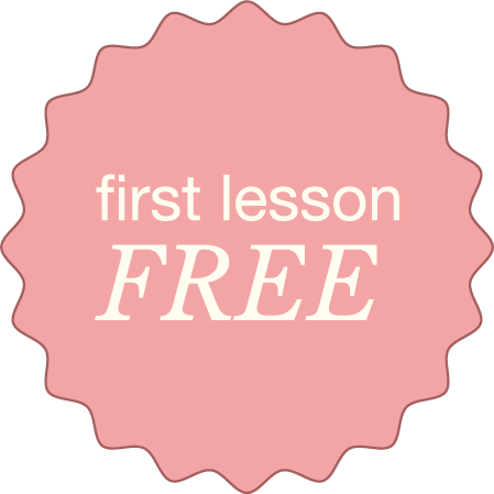 Pink badge with scalloped edges displaying the text "first lesson FREE" in white and light pink letters.