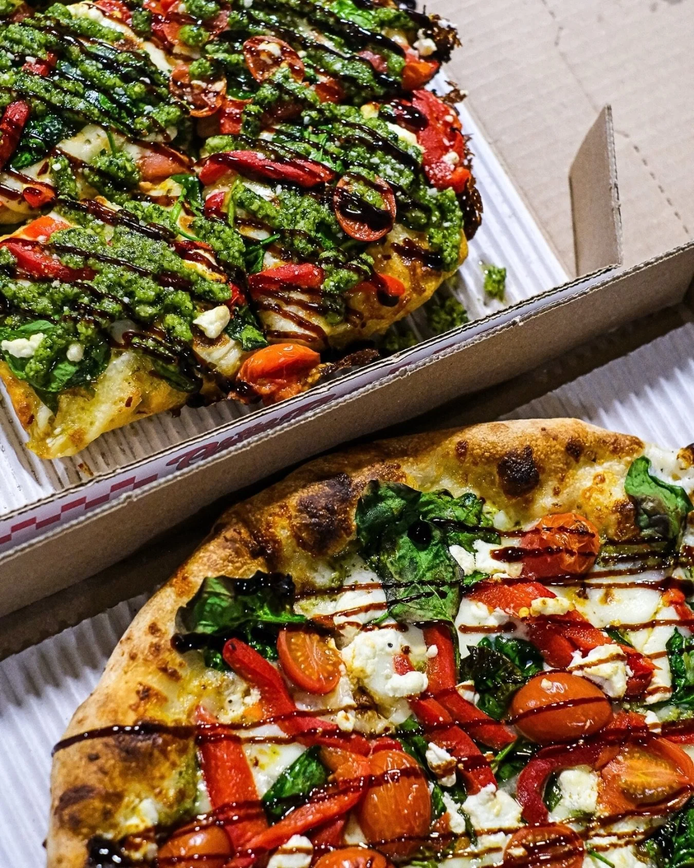 Our Drivin&rsquo; Me Caprese pizza is everything you could want: pesto, mozzarella and goat cheese, roasted red peppers, spinach, and finished with a drizzle of balsamic ✨