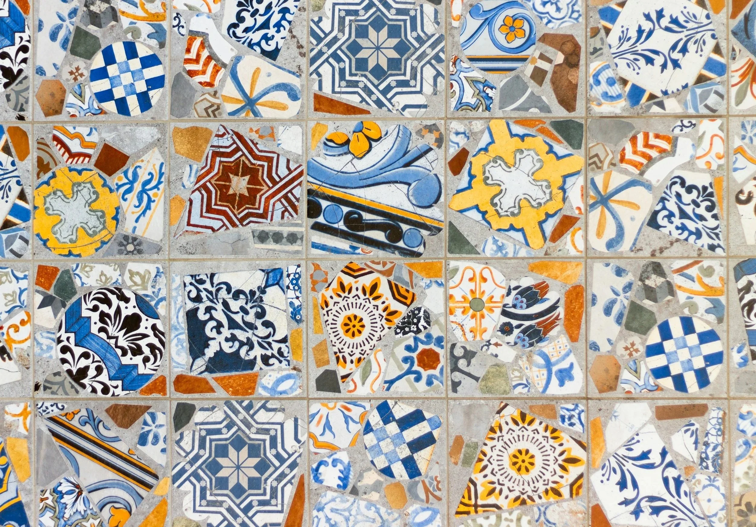 Colorful decorative tiles with intricate patterns in blue, yellow, white, orange, black, and gray.