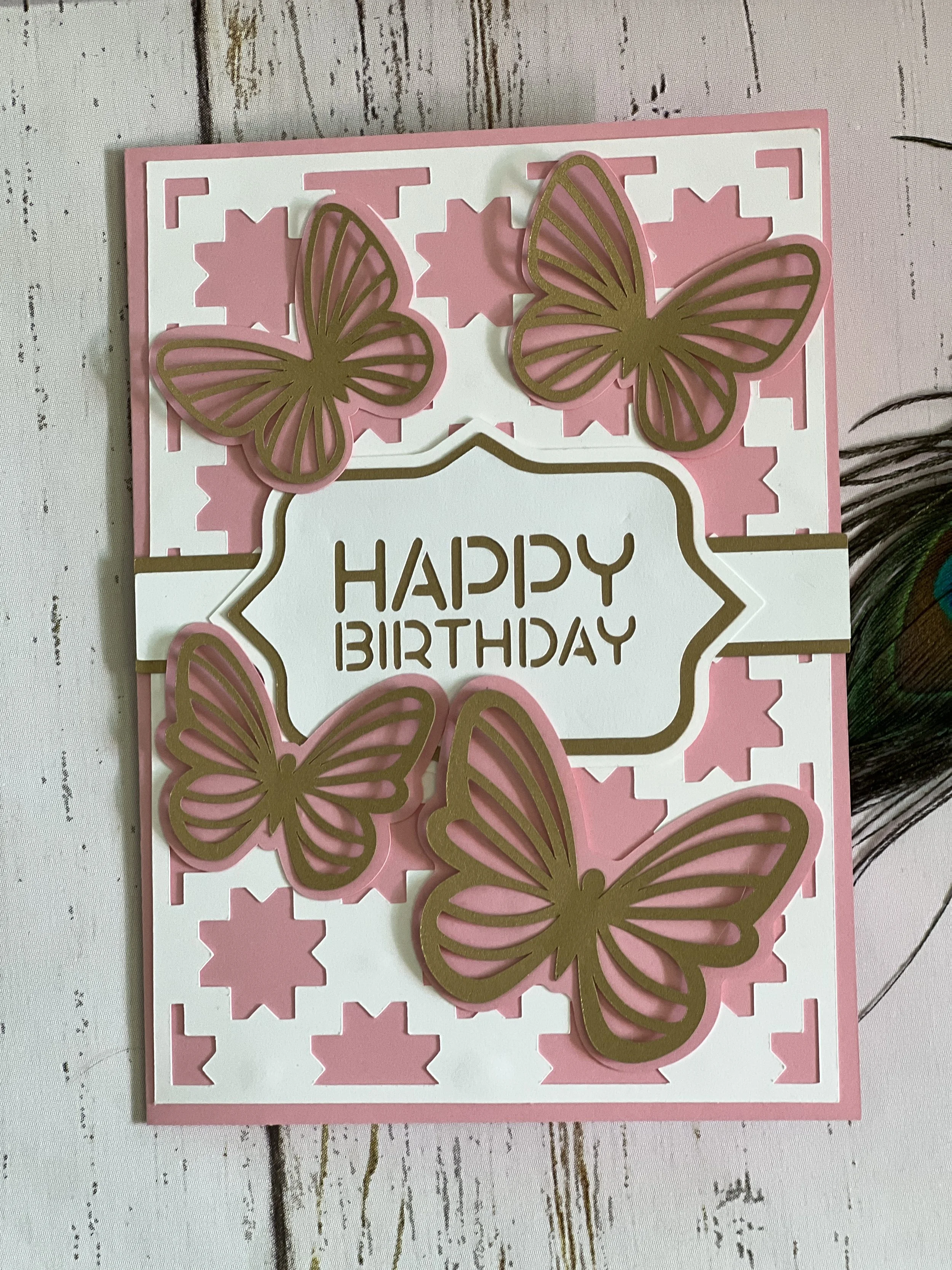 Pink and white birthday card with gold butterfly decorations and the message 'Happy Birthday' in the center.