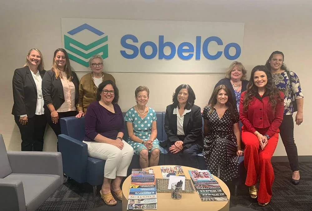 Group of ten women in an office setting.