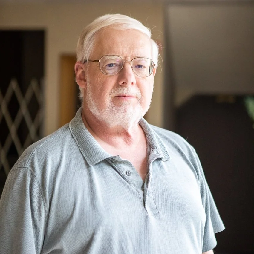 Ken Morse, Jericho Road Ministries' Business Office Assistant looking at the camera indoors.
