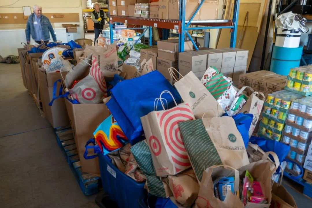 Packed grocery bags, boxes, and food supplies donated to Jericho Road Ministries from a local food drive.