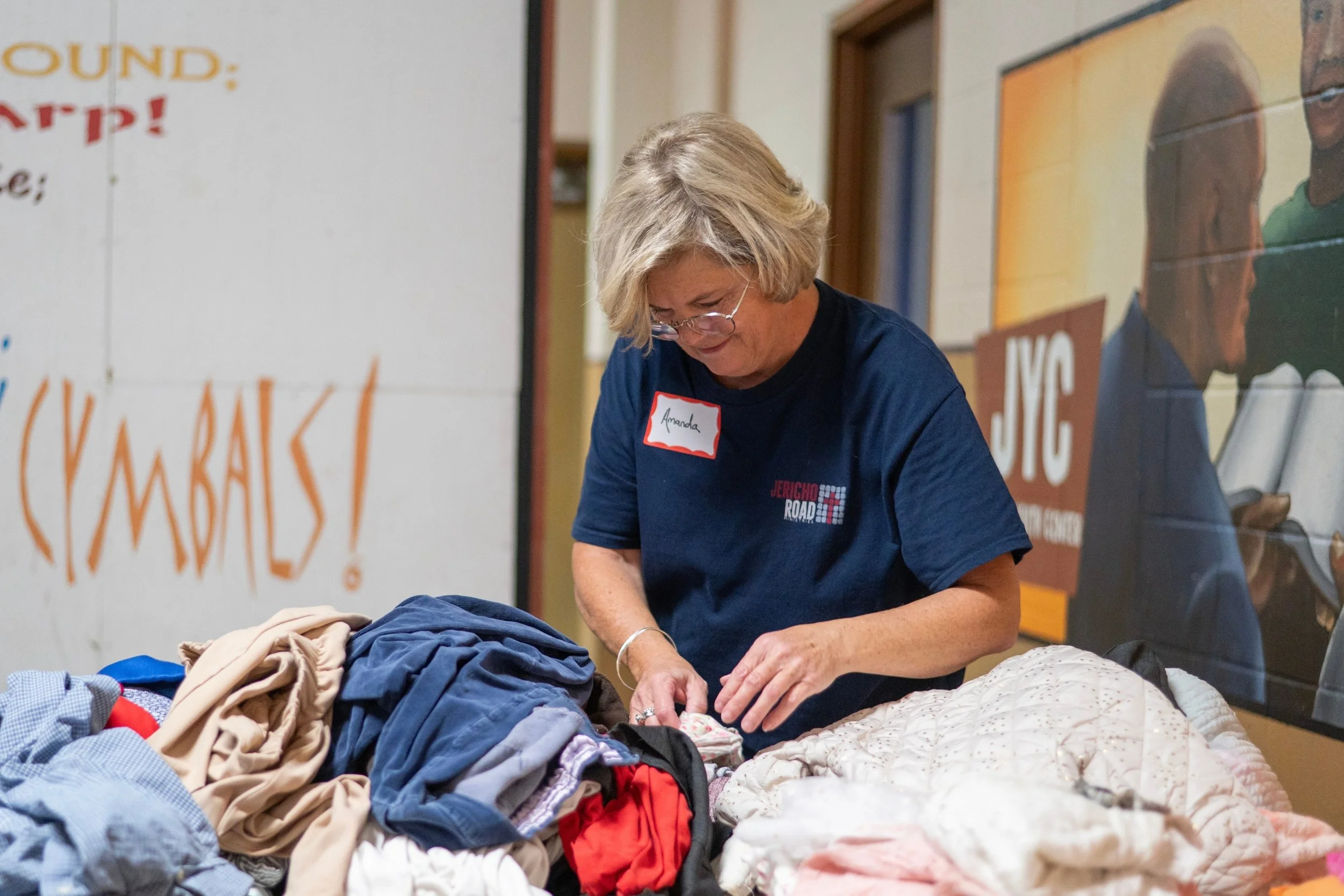 A woman sorting clothes on a table during an event at Jericho Road Ministries in Minneapolis, Minnesota.
