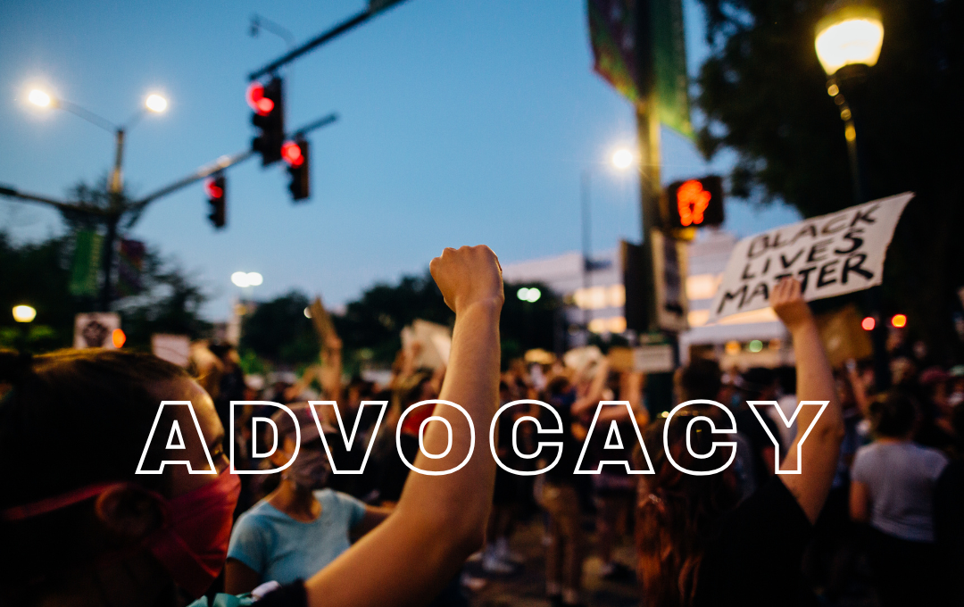 Crowd of people protesting at night holding signs, one reading "Black Lives Matter," with the word "Advocacy" overlaid.