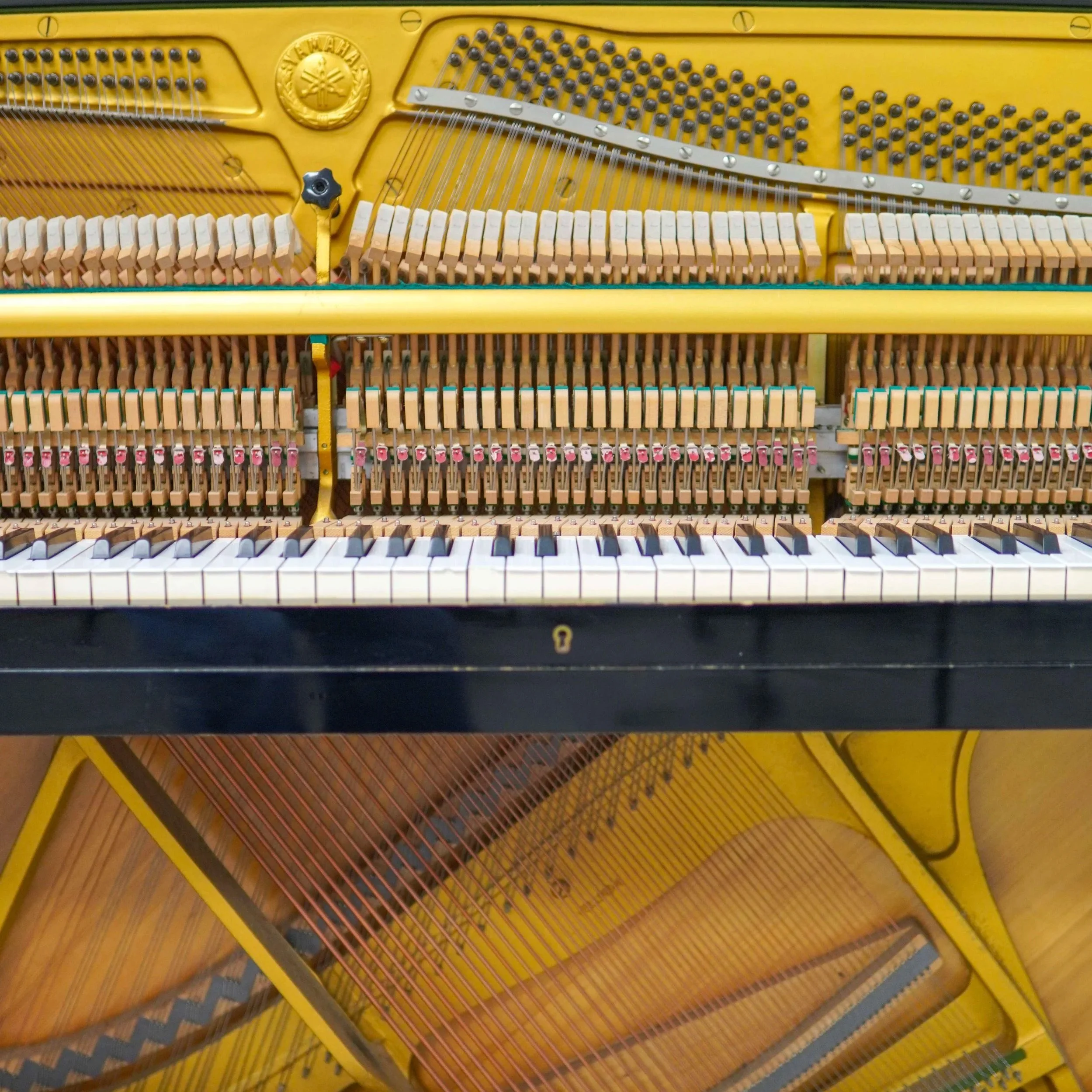 Close-up of an old, weathered piano with damaged keys and worn wood, showing a rustic, vintage appearance.