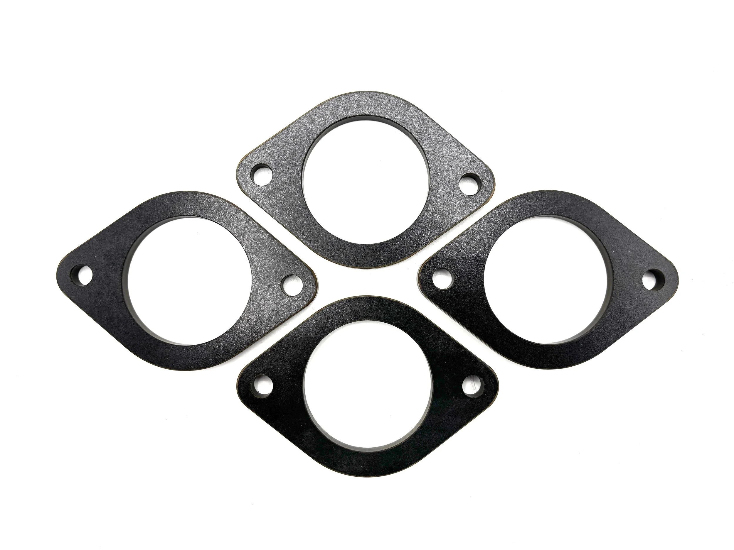 Four Black Phenolic Carburetor spacer. Circular in shape with one big hole in the middle and two bolt holes on the side.